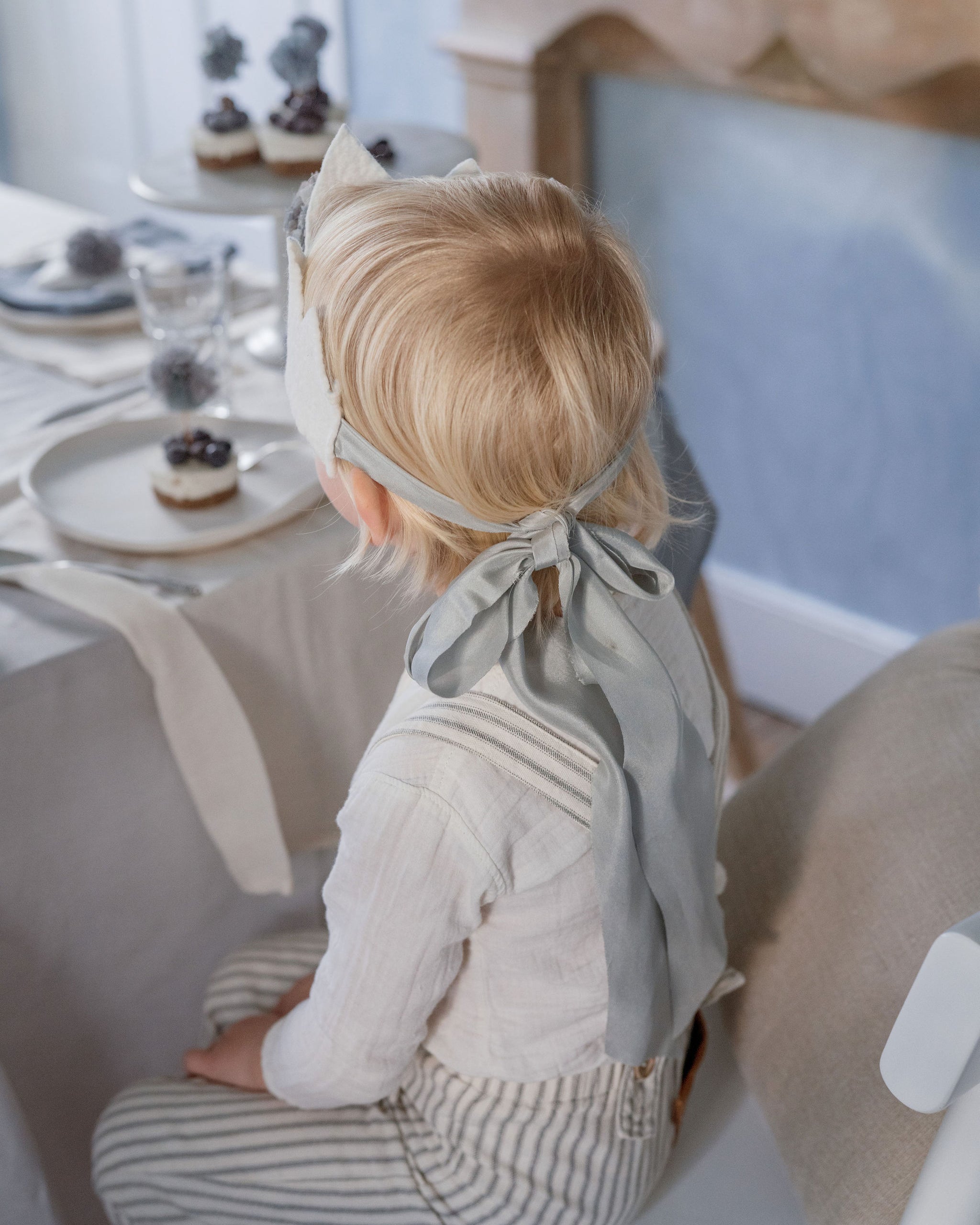 Child sitting at a dining table with a neutral color scheme