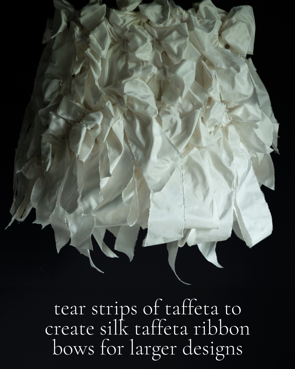 White silk taffeta ribbon bow against a black background