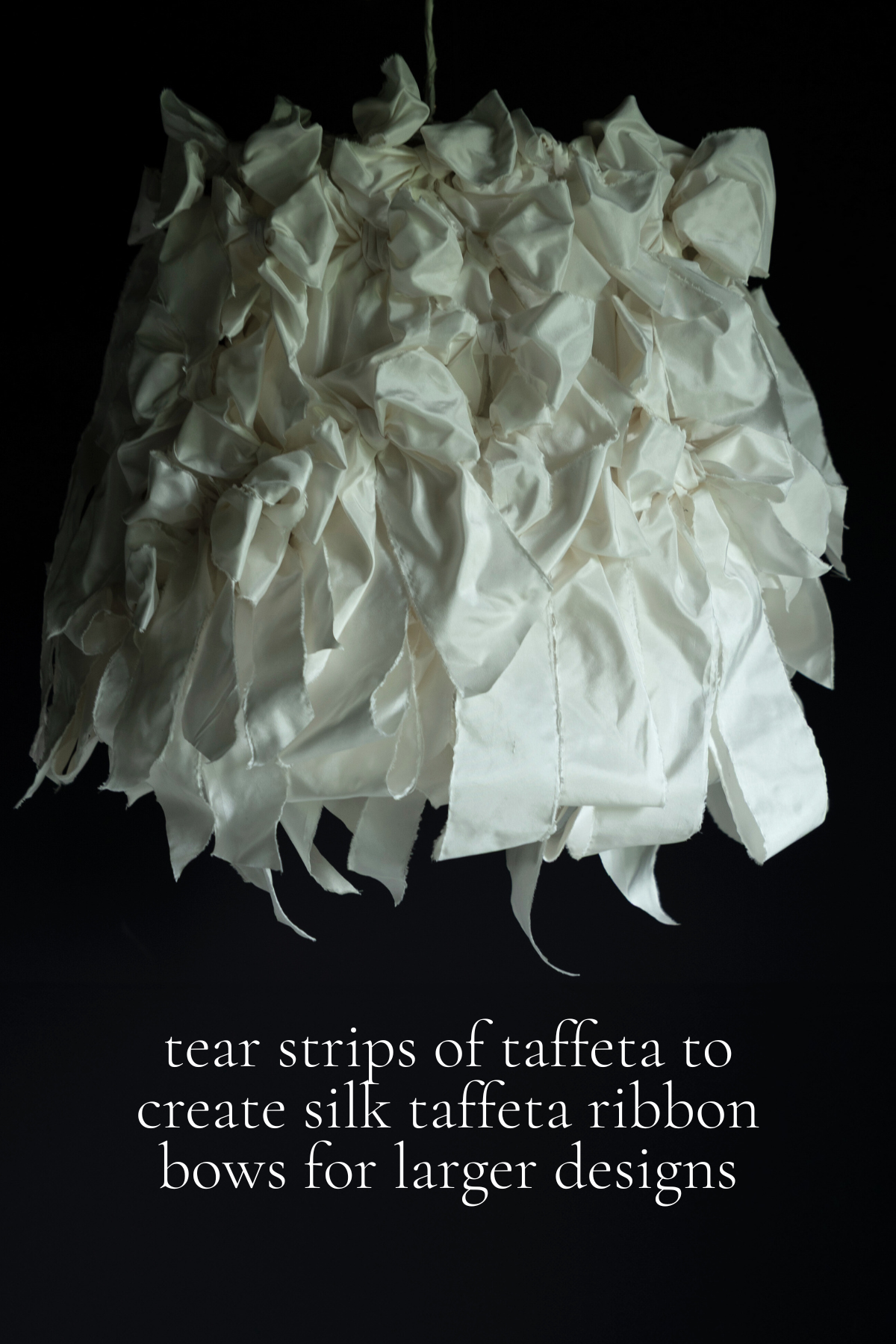 White silk taffeta ribbon bow against a black background
