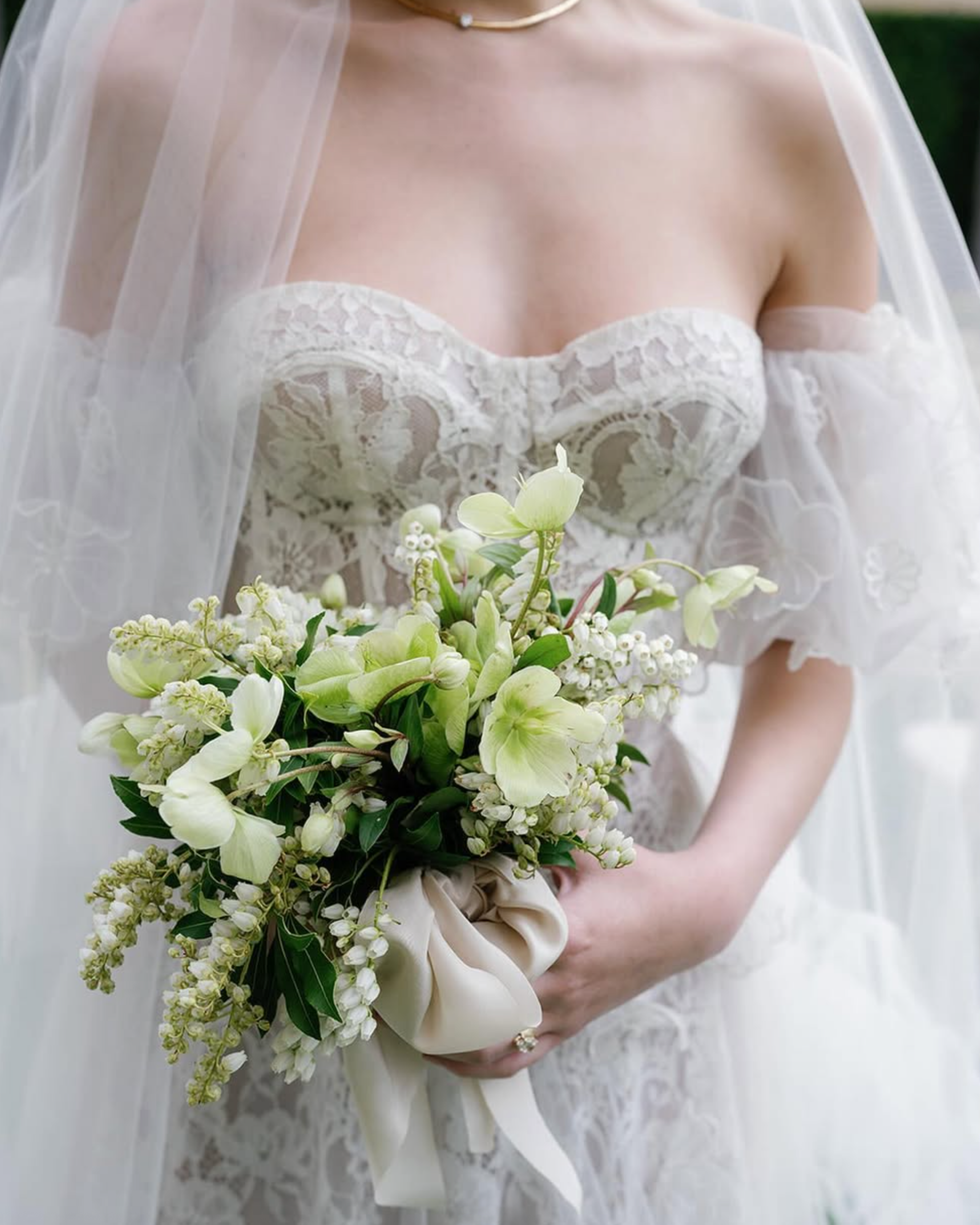 bride holding lily of the valley bridal bouquet wrapped with silk and willow silk ribbon