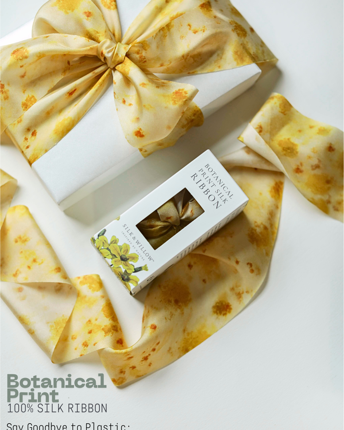 Silk ribbon with a box of botanical print ribbon next to a gift wrapped box with yellow ribbon bow on a white background