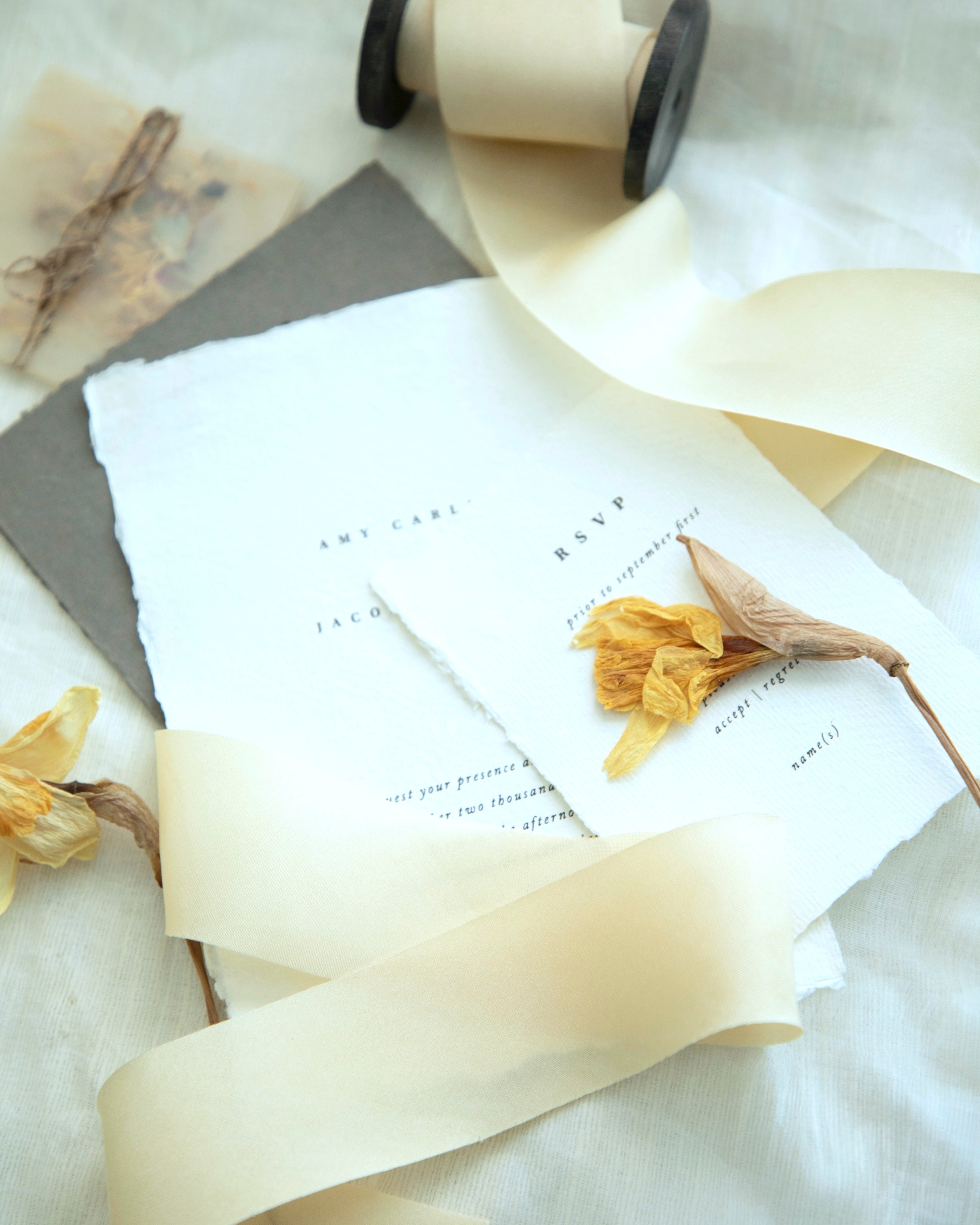 custom invitation flatlay with antique gold silk ribbon