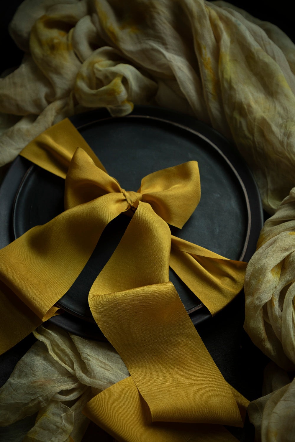 Gold plant-dyed silk ribbons not only elevate floral arrangements but also add a touch of elegance to wedding table decor elements. Their versatile nature allows for creative applications, from delicate bow ties on wedding favours to stunning drapery for table settings. Available in a range of organic colours inspired by nature, each ribbon offers a unique story, enhancing the overall aesthetic of the occasion.