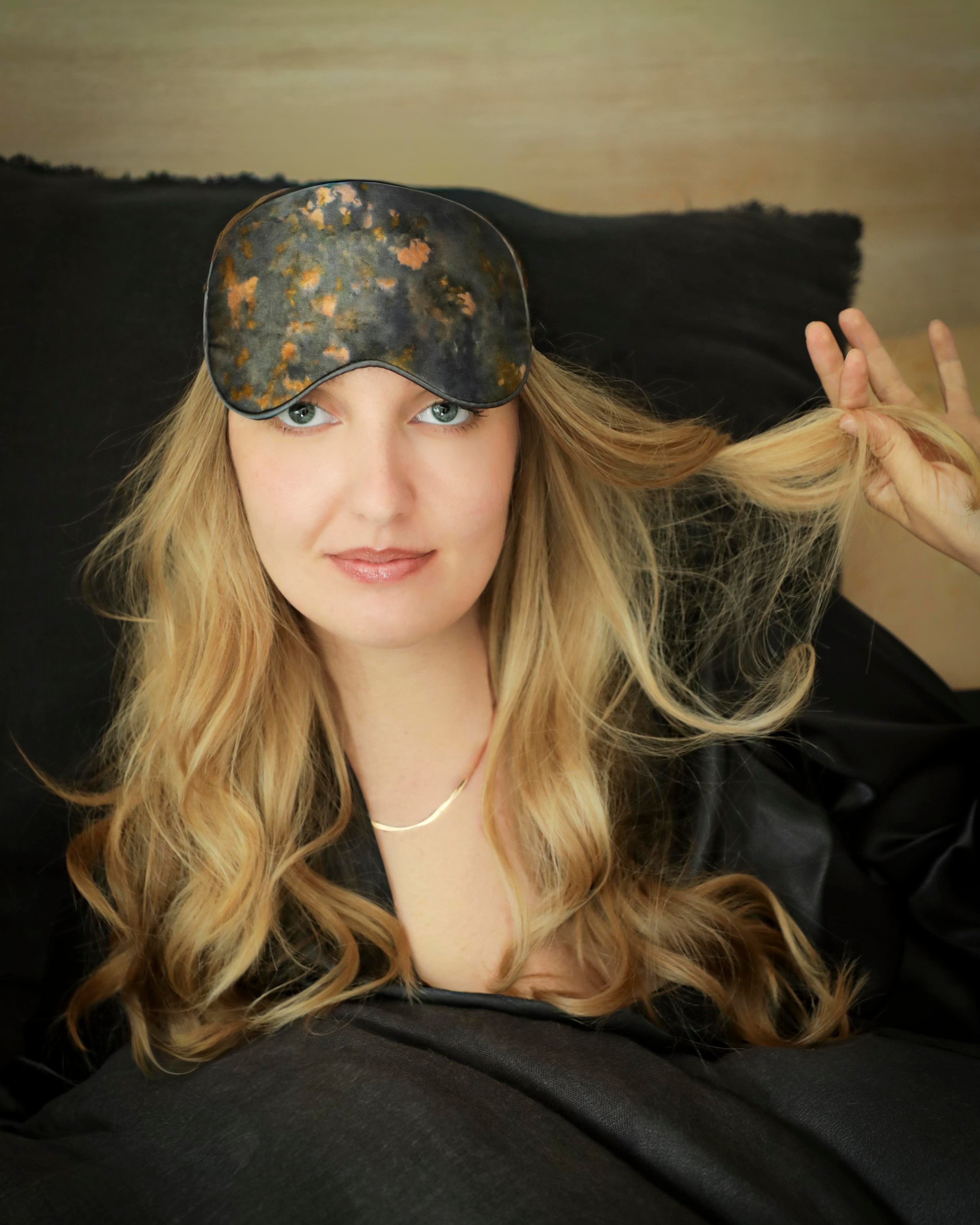 Woman wearing a decorative silk sleep mask with a blurred background