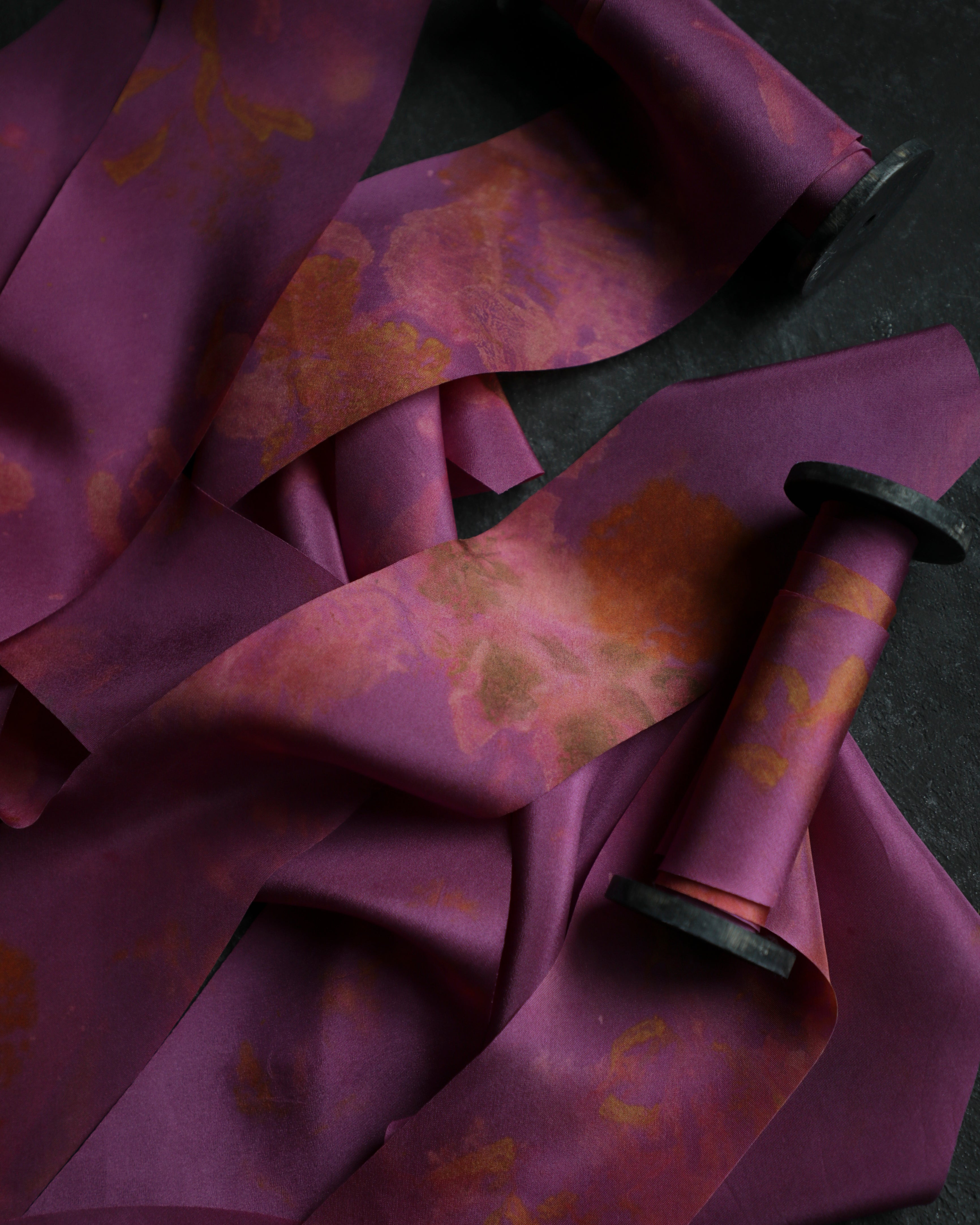 hot pink silk ribbon with eco-print patterns on a dark background