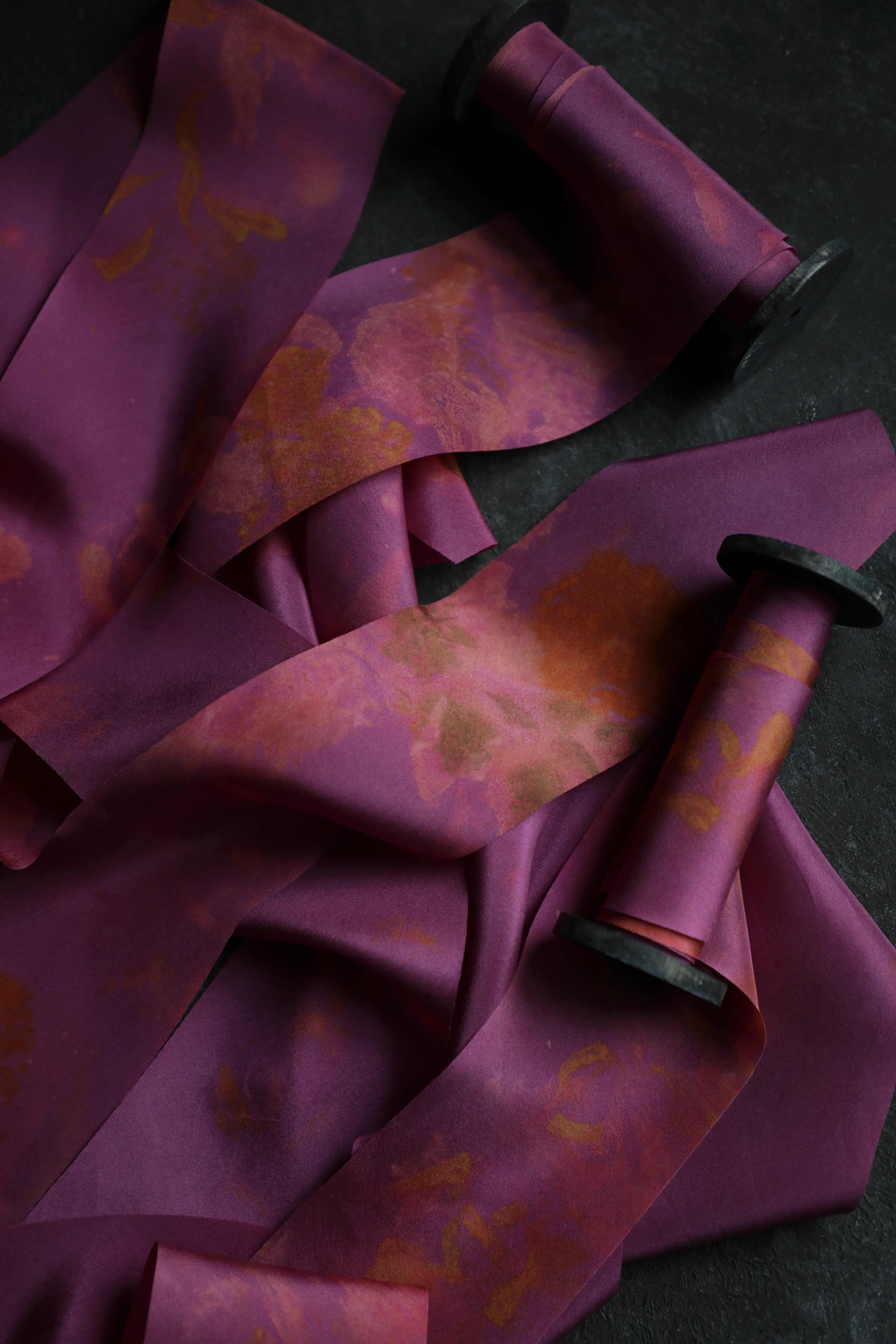 hot pink silk ribbon with eco-print patterns on a dark background