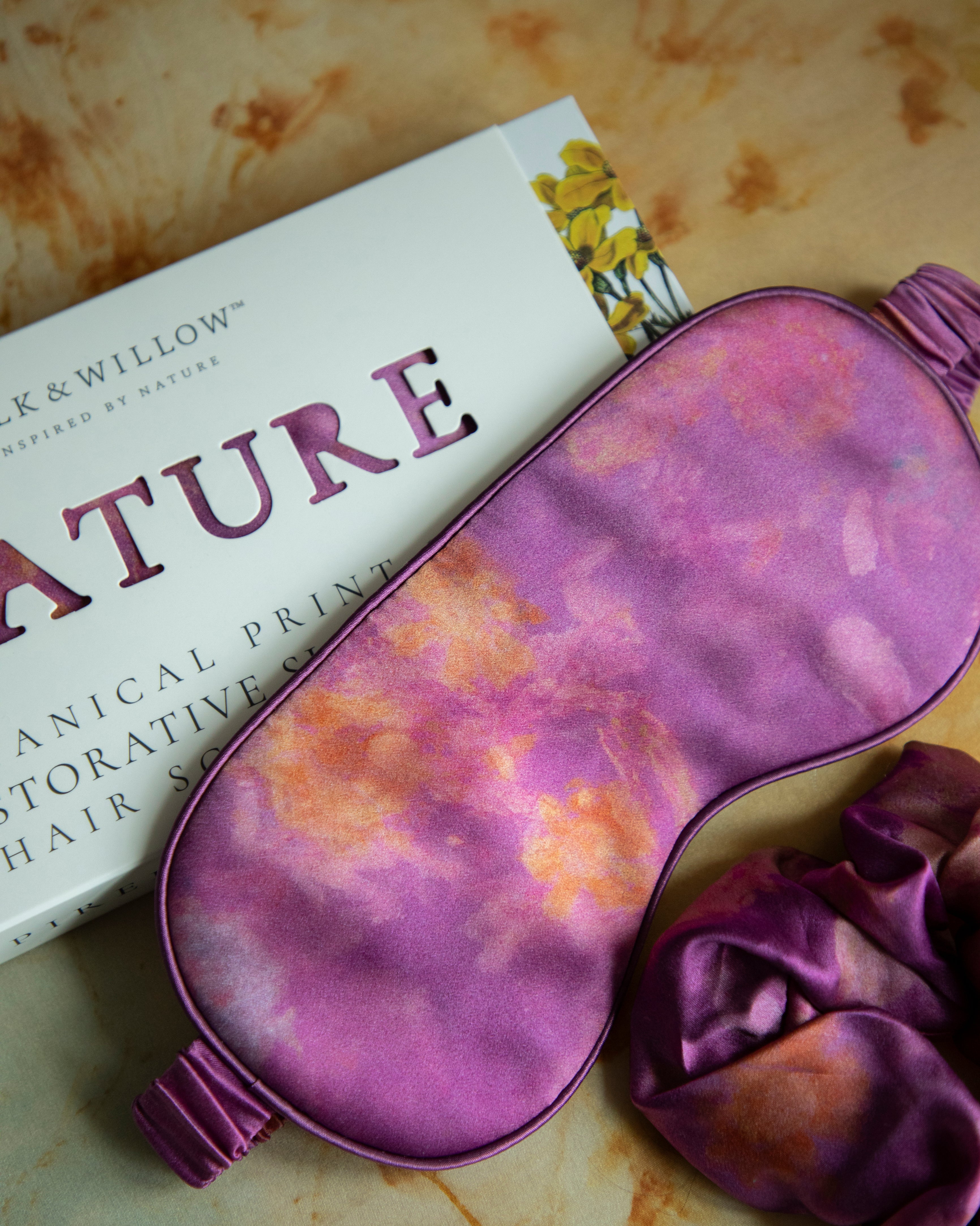 A luxurious silk sleep mask and hair scrunchie set featuring delicate botanical patterns, elegantly displayed in a sustainable gift box, perfect for a sophisticated and eco-conscious touch.