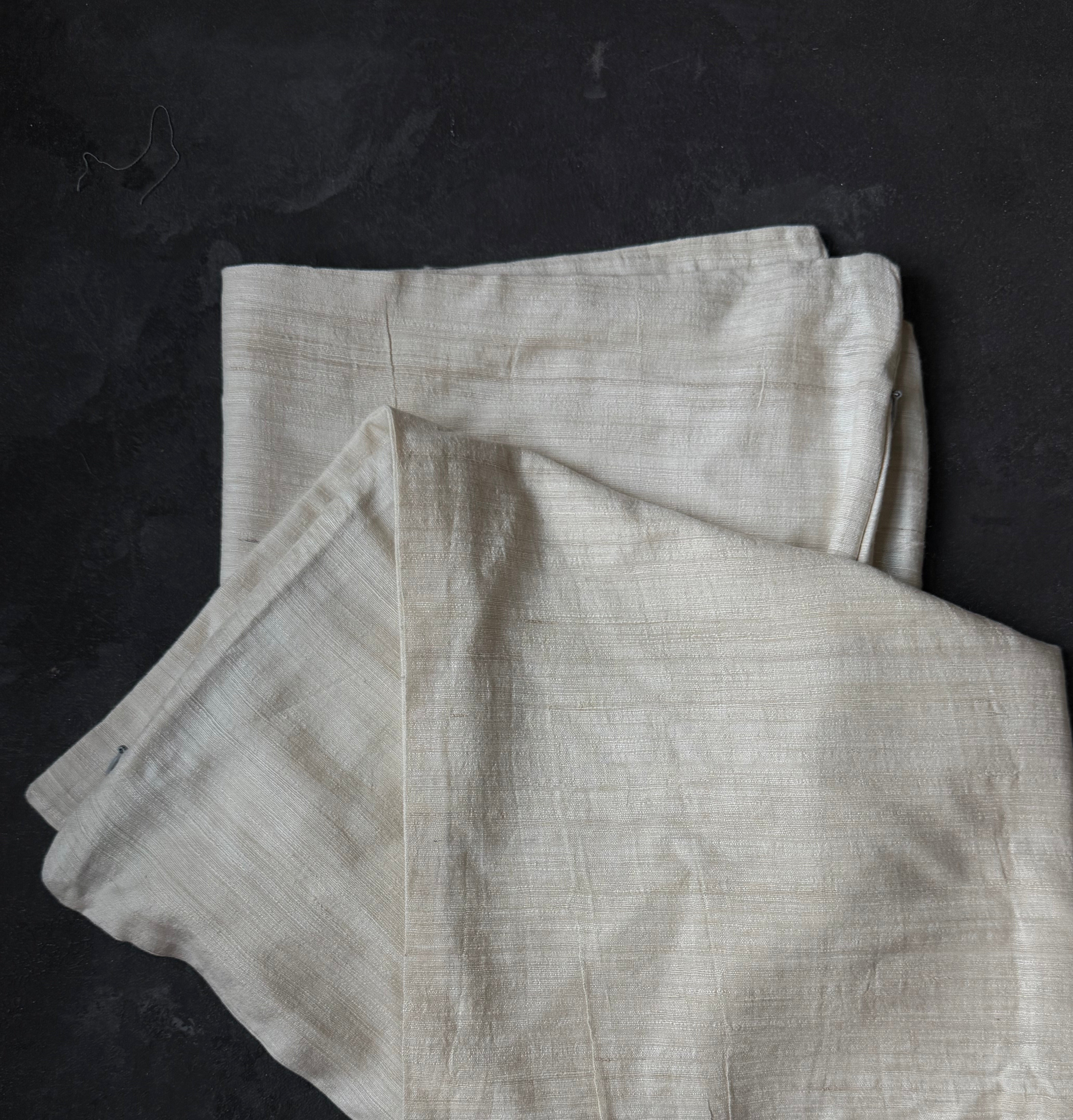 Folded light gray fabric on a dark surface