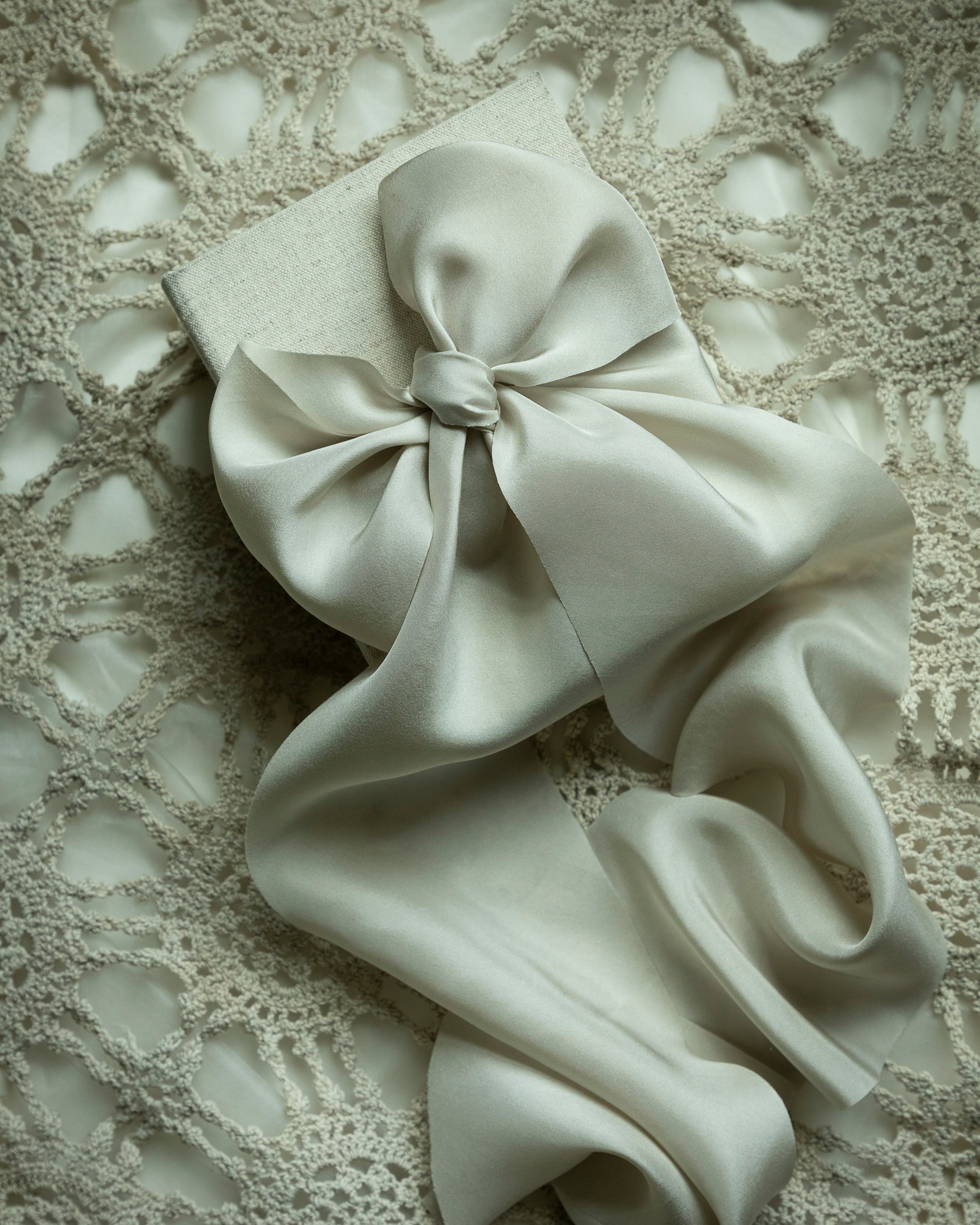 White bow on a textured beige background