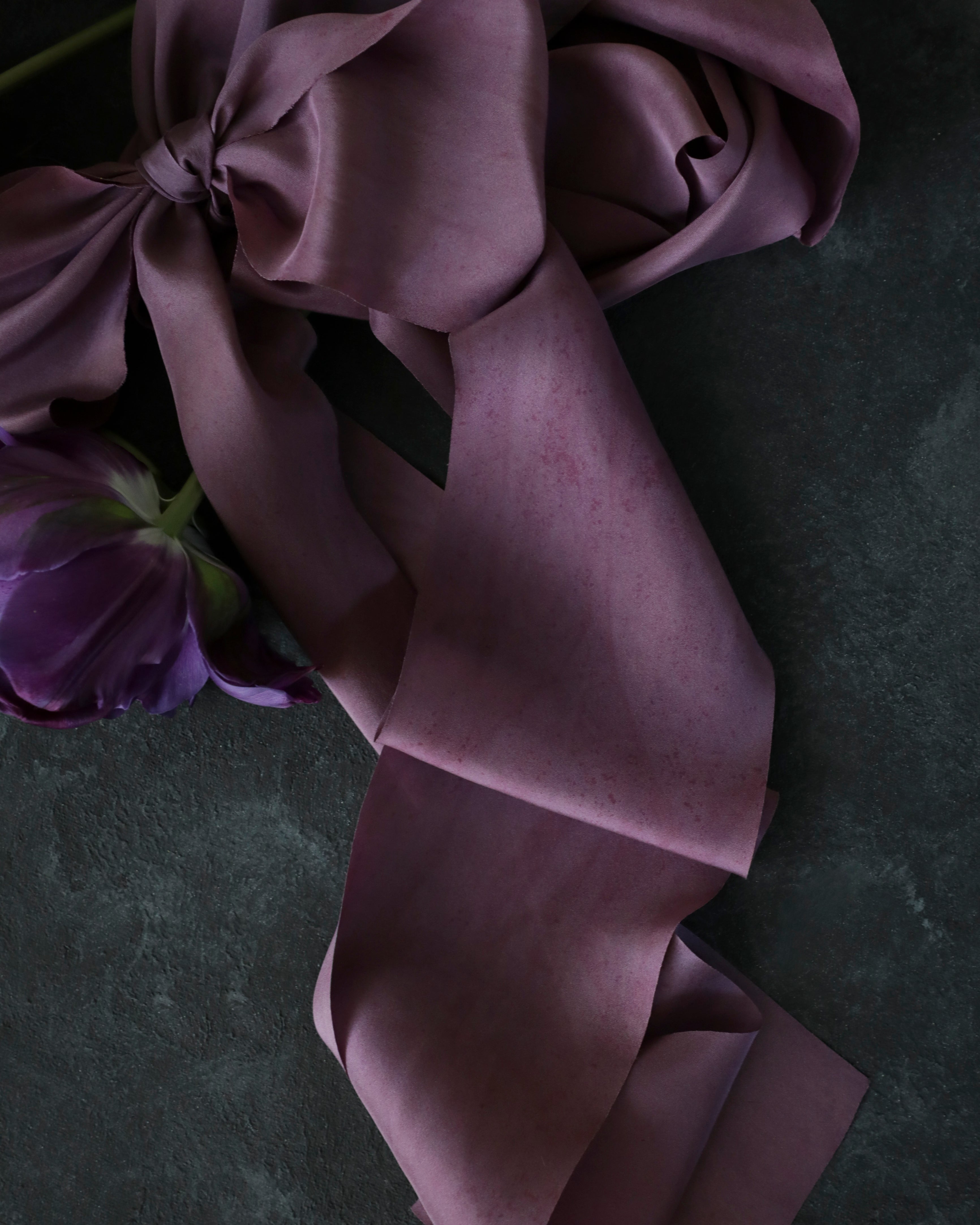 close up of purple ribbon against black background