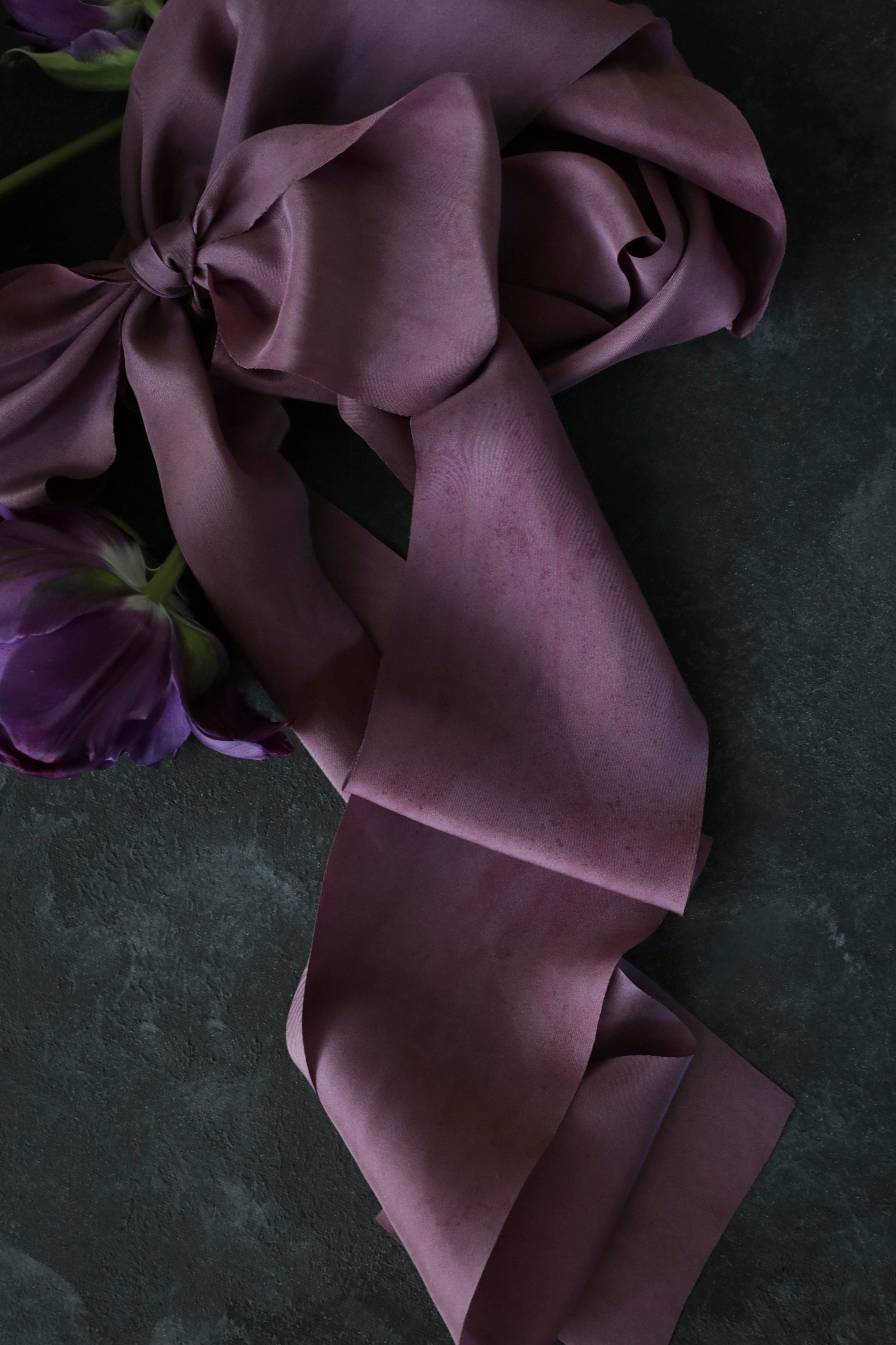 close up of purple ribbon against black background