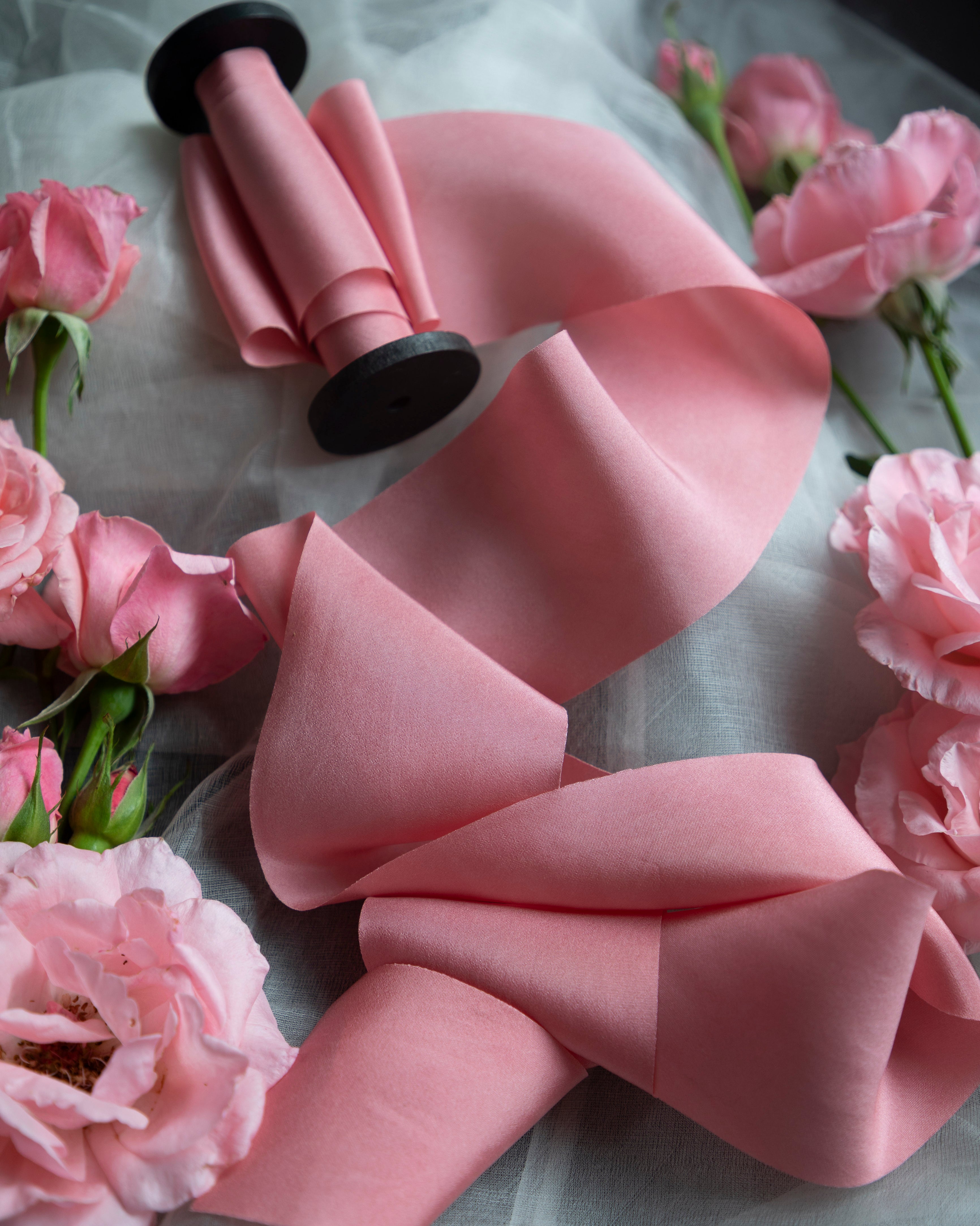 Pink bow with black centers on a gray background with pink flowers
