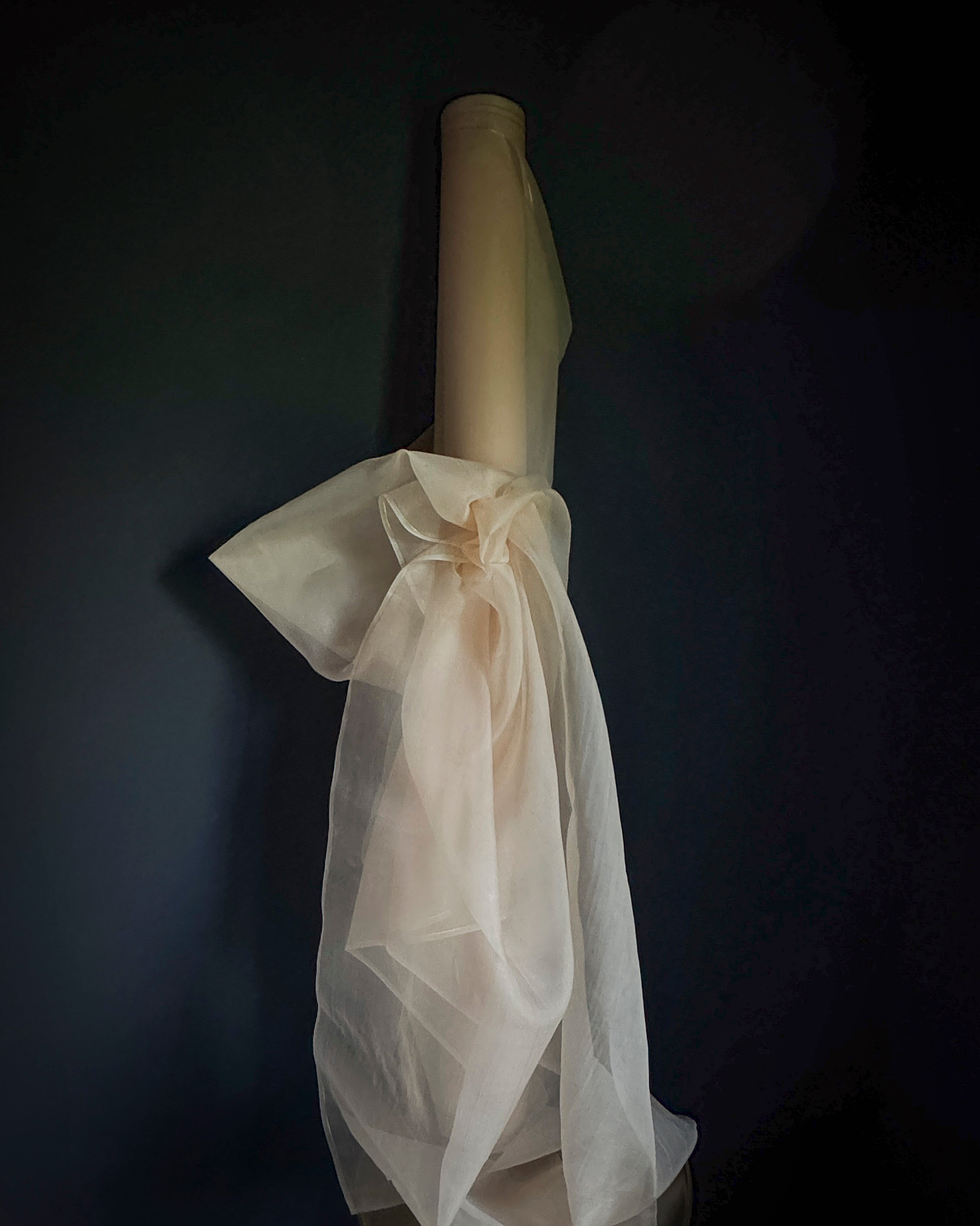 Roll of silk organza pink fabric against a dark background