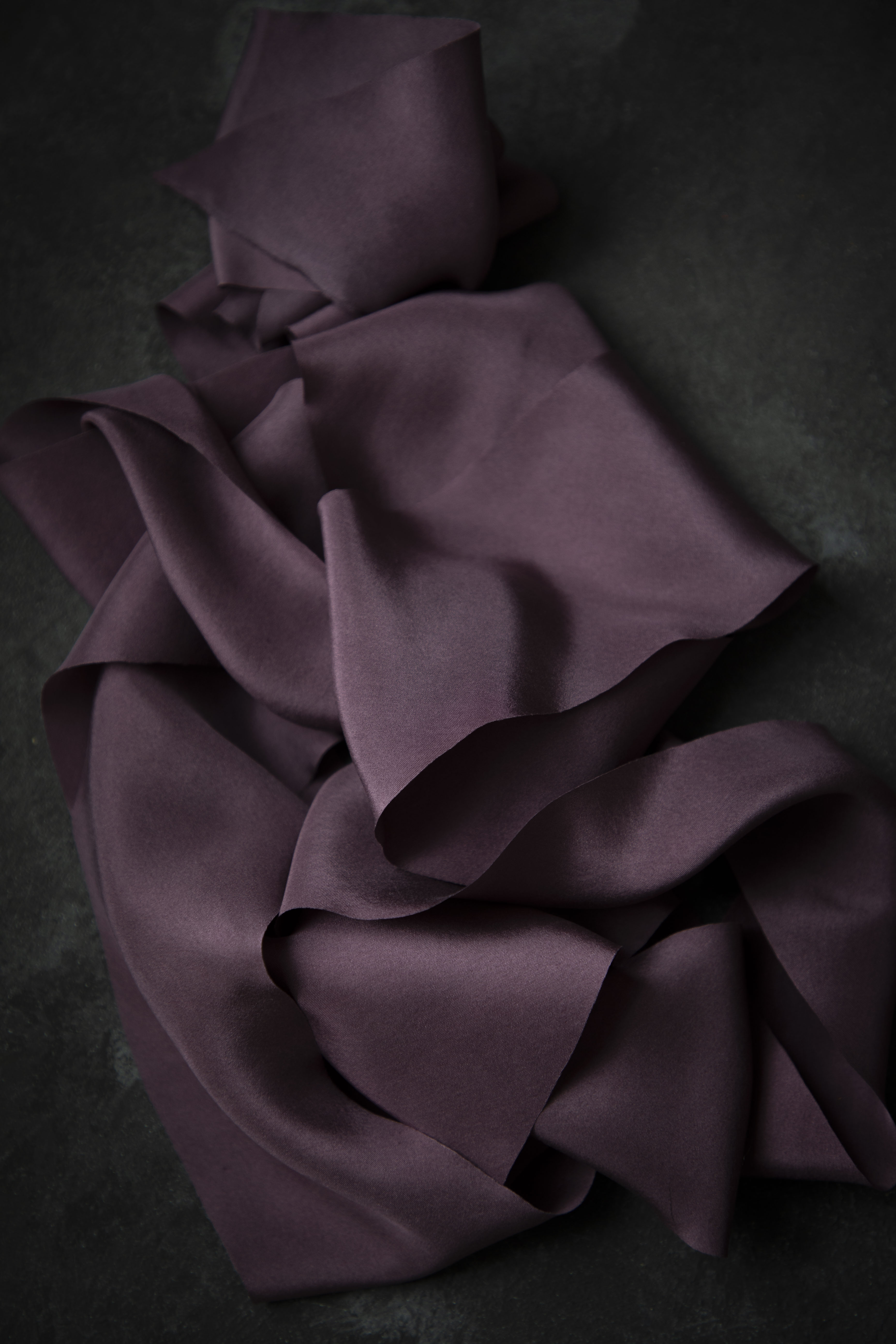 Purple ribbon draped over a dark surface