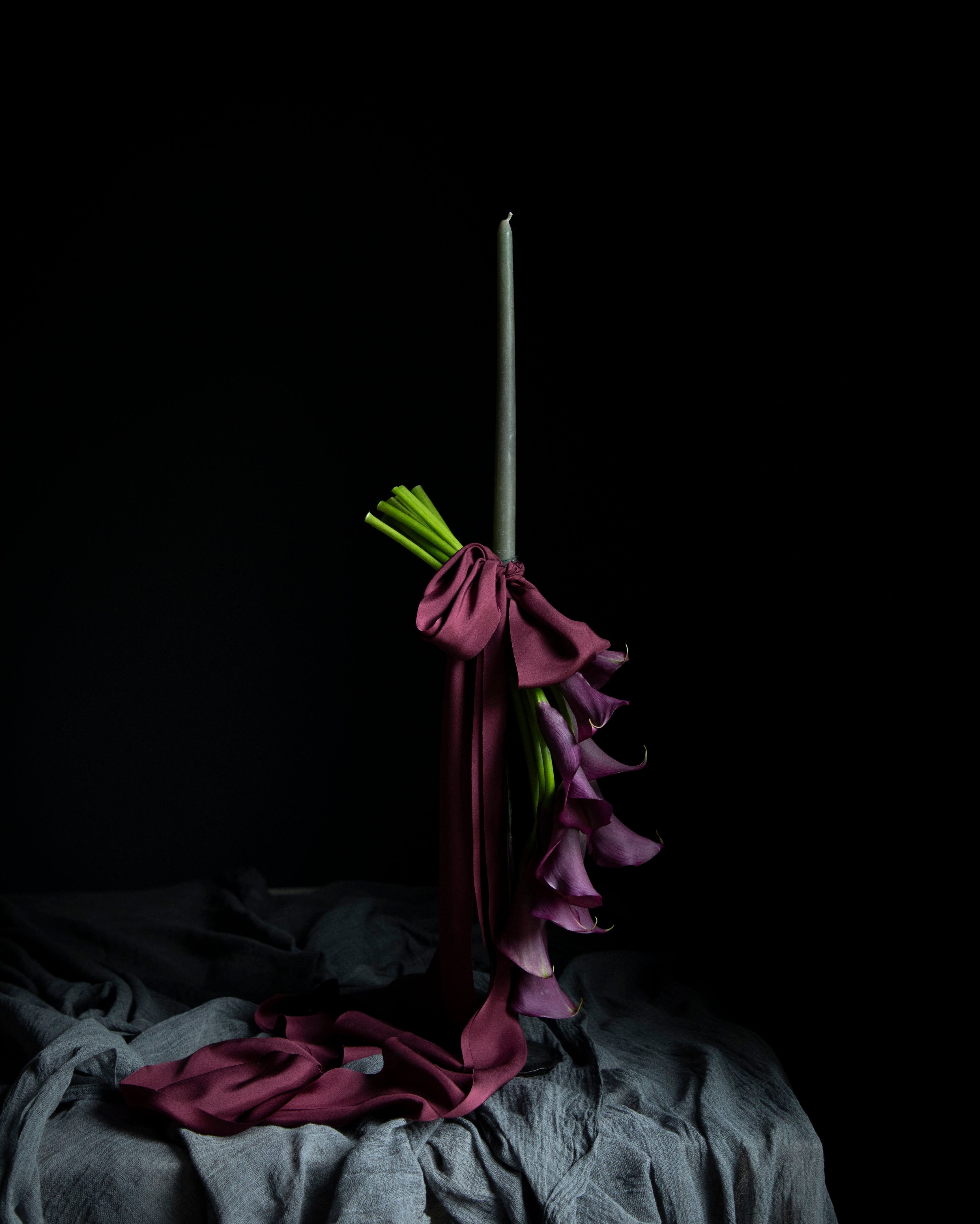 purple calla lilies on a candle display tied with purple silk ribbons