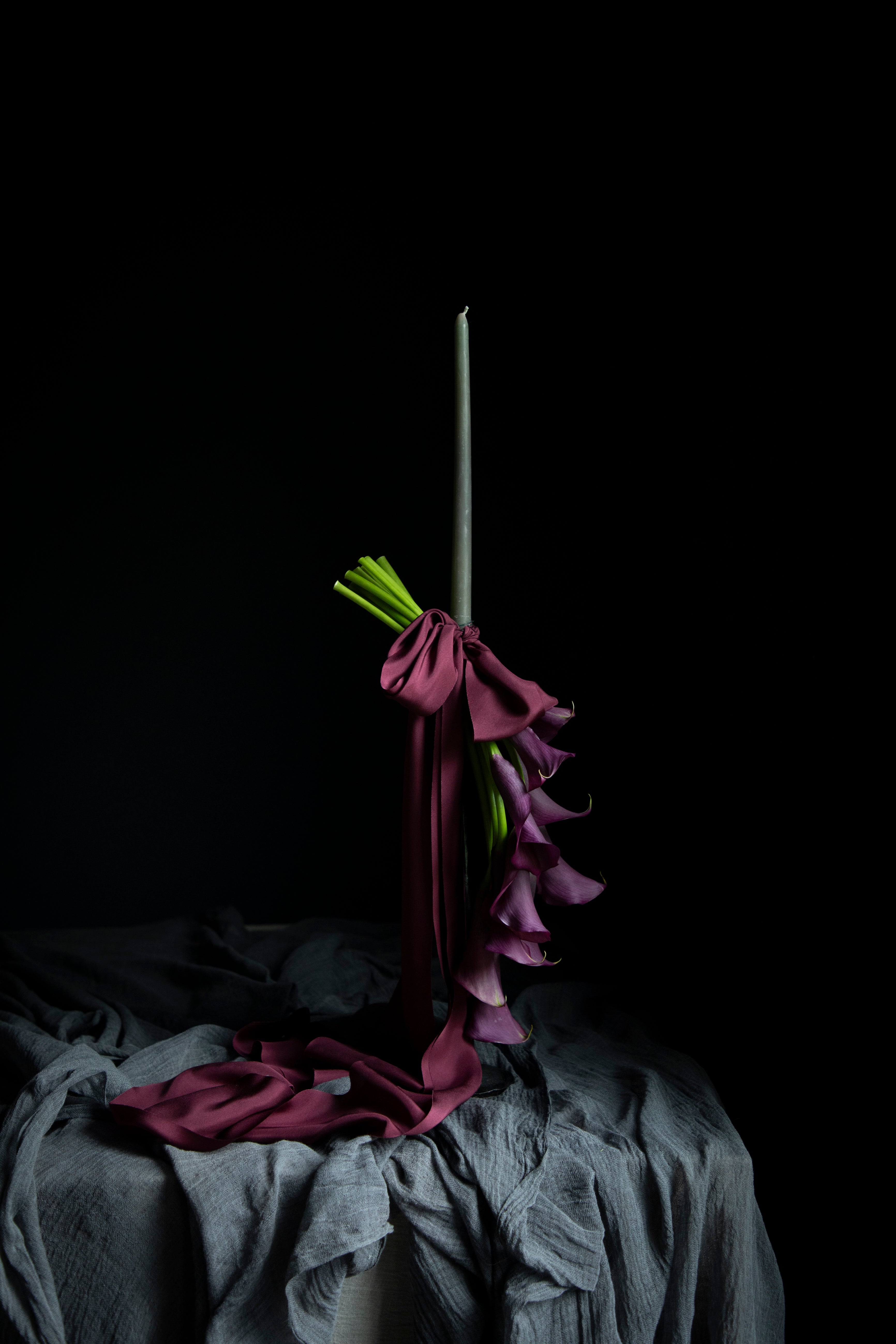 purple calla lilies on a candle display tied with purple silk ribbons