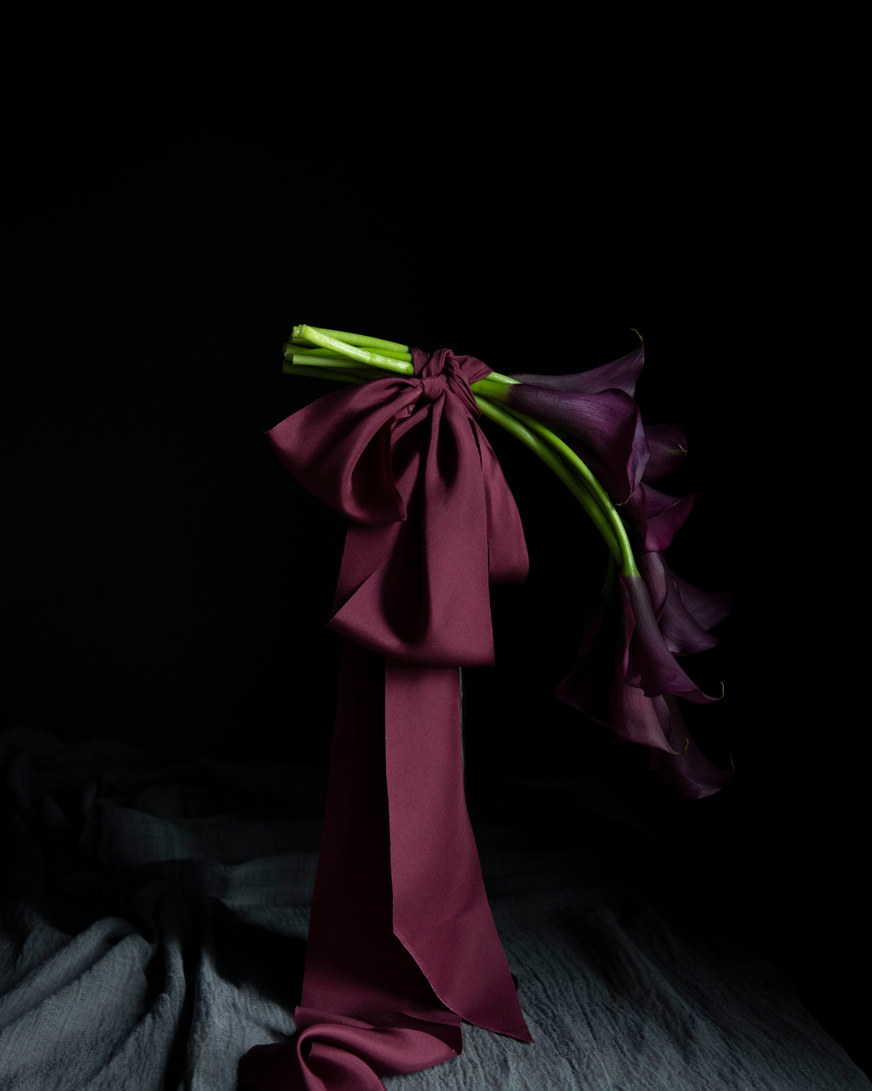 floating purple calla lily flowers tied with purple ribbon bows