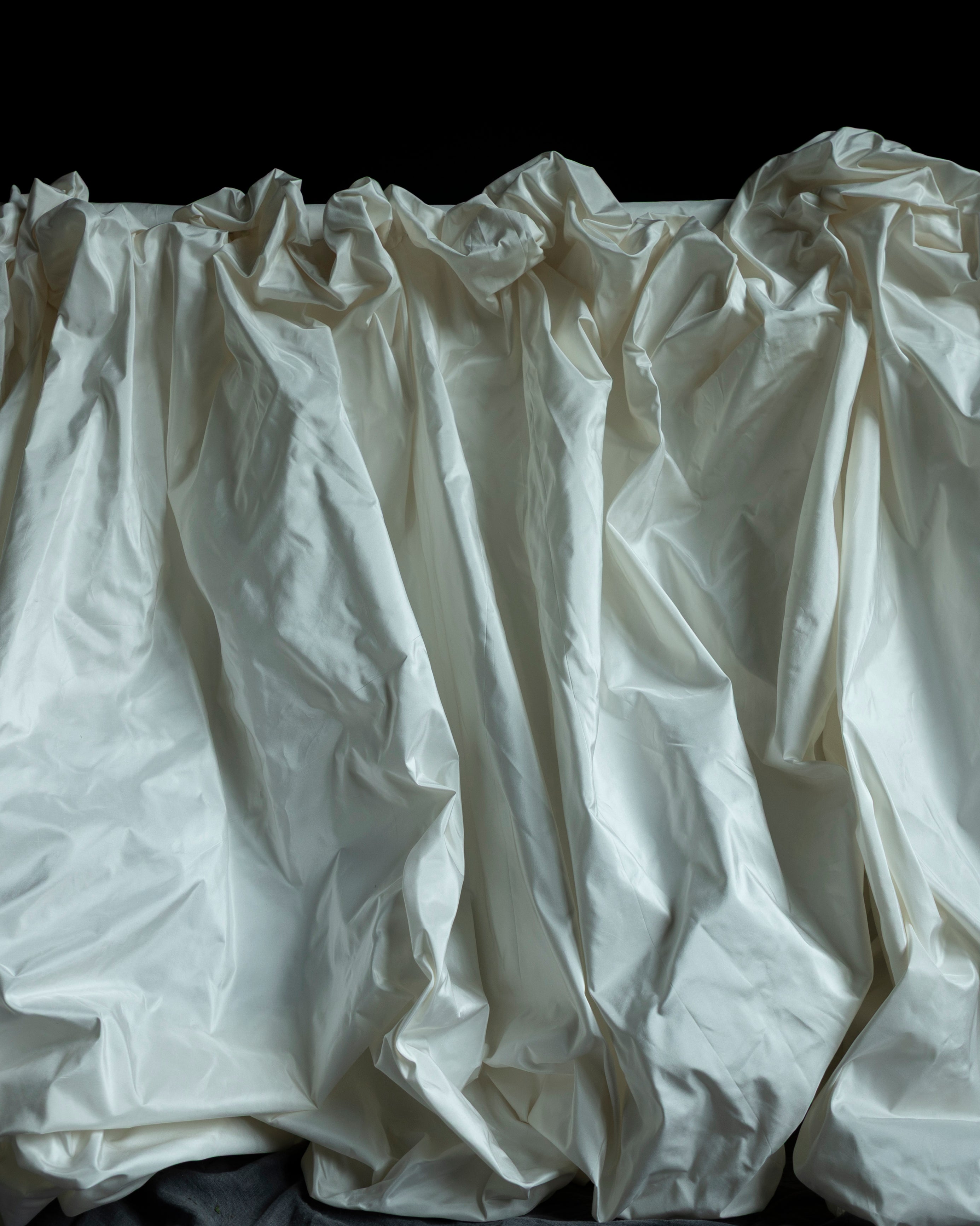 White fabric with ruffled top on a black background