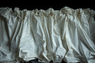 White fabric with ruffled top on a black background