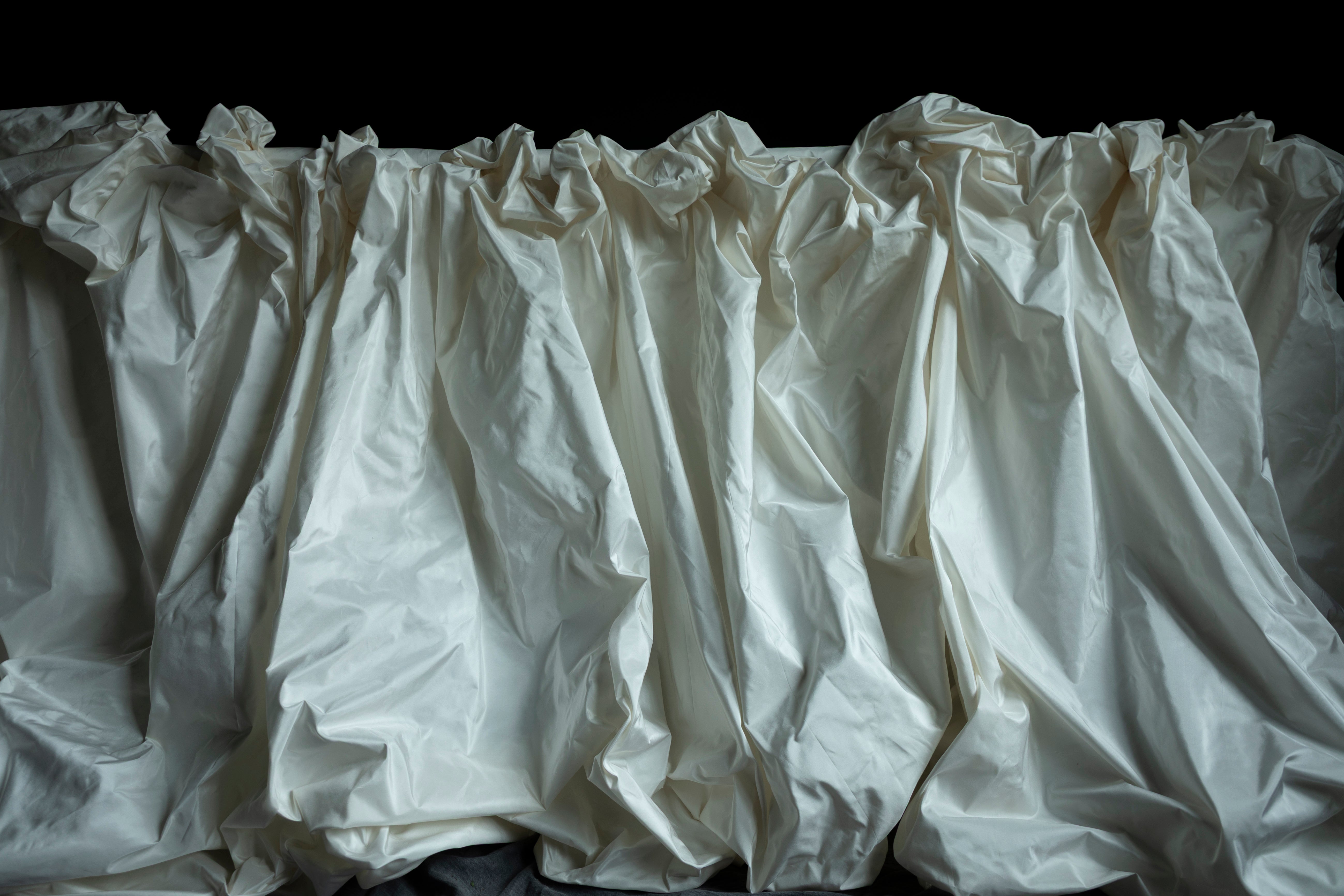 White fabric with ruffled top on a black background