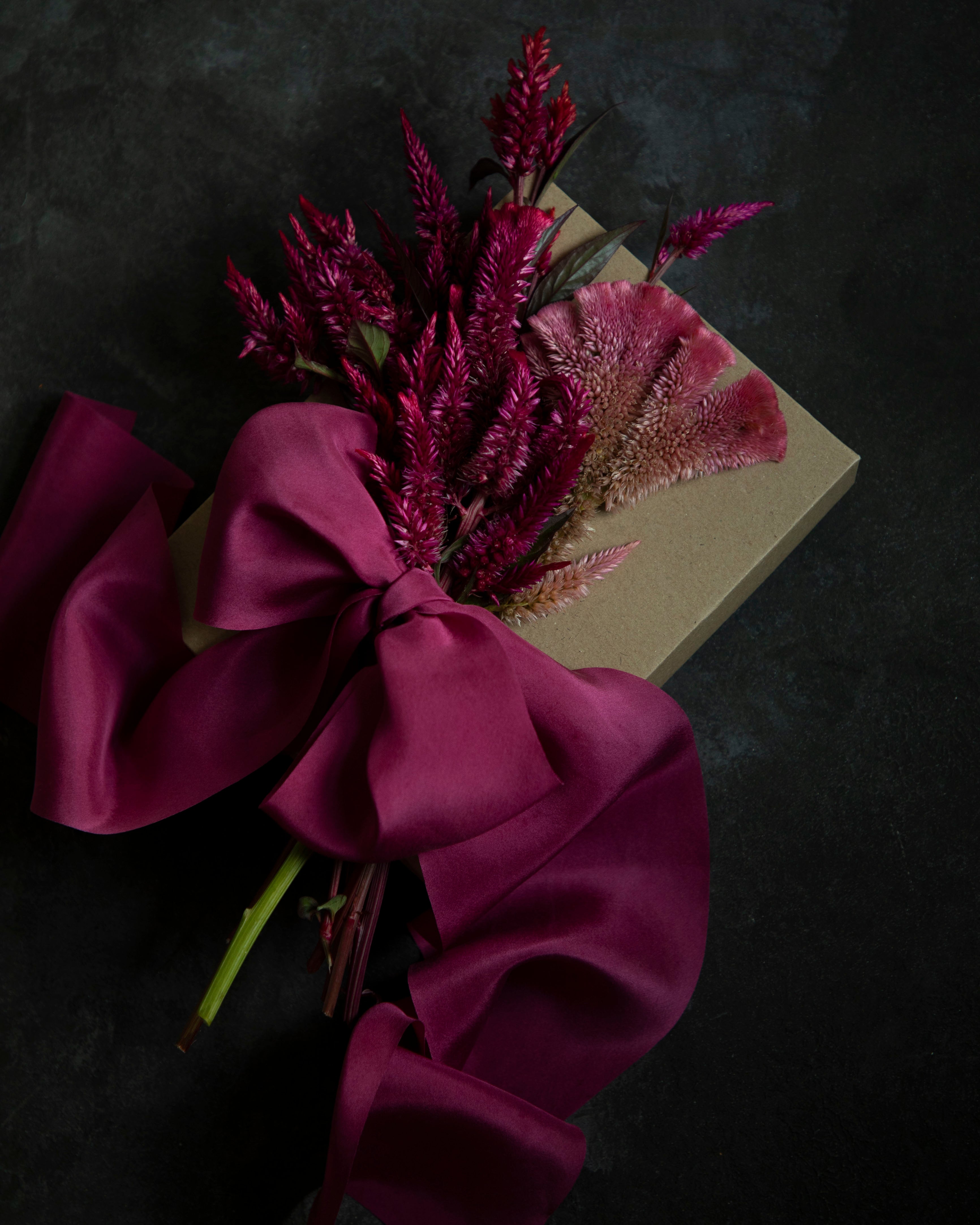 gift wrapped with hot pink silk ribbon and topped with dried floral arrangement