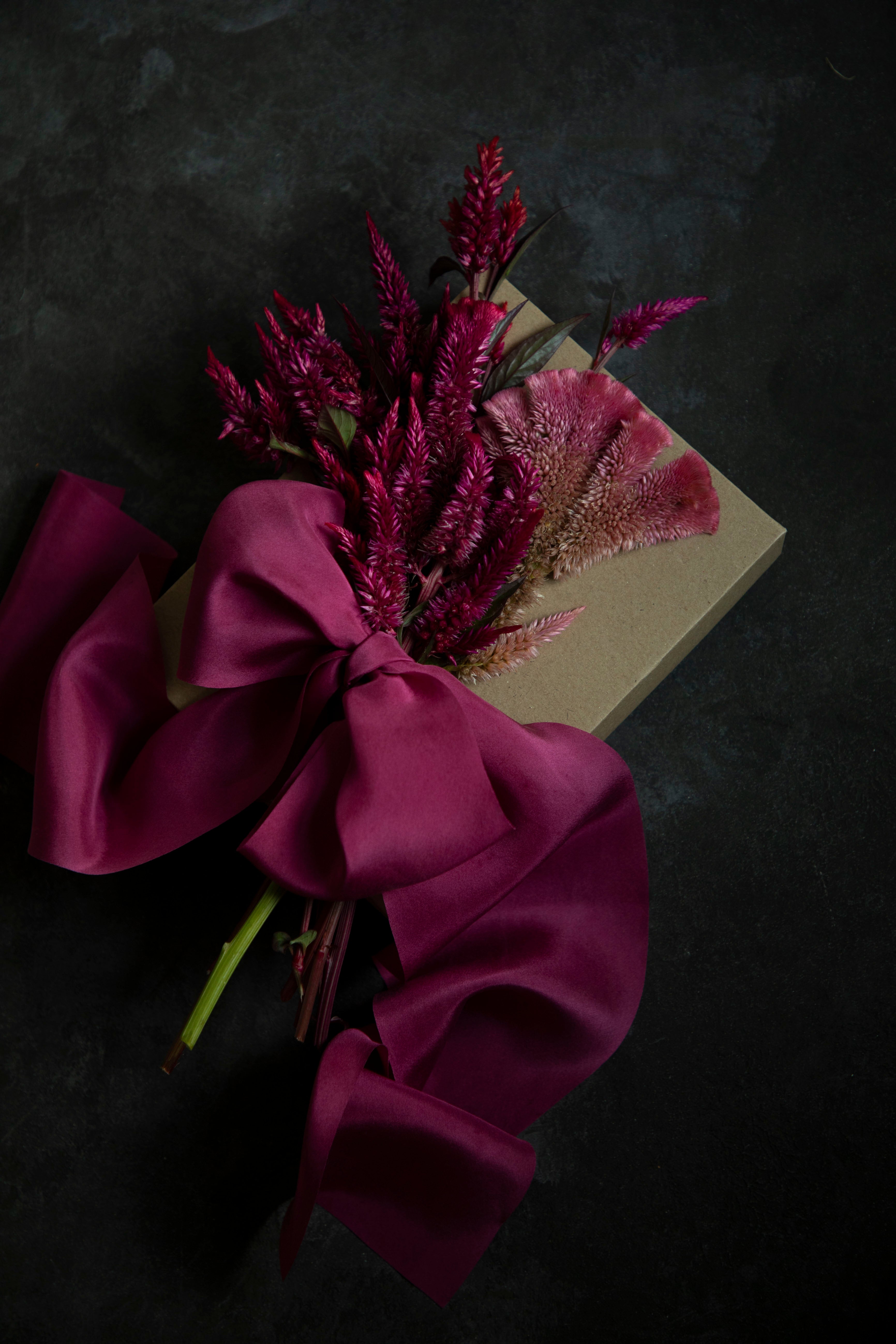 gift wrapped with hot pink silk ribbon and topped with dried floral arrangement