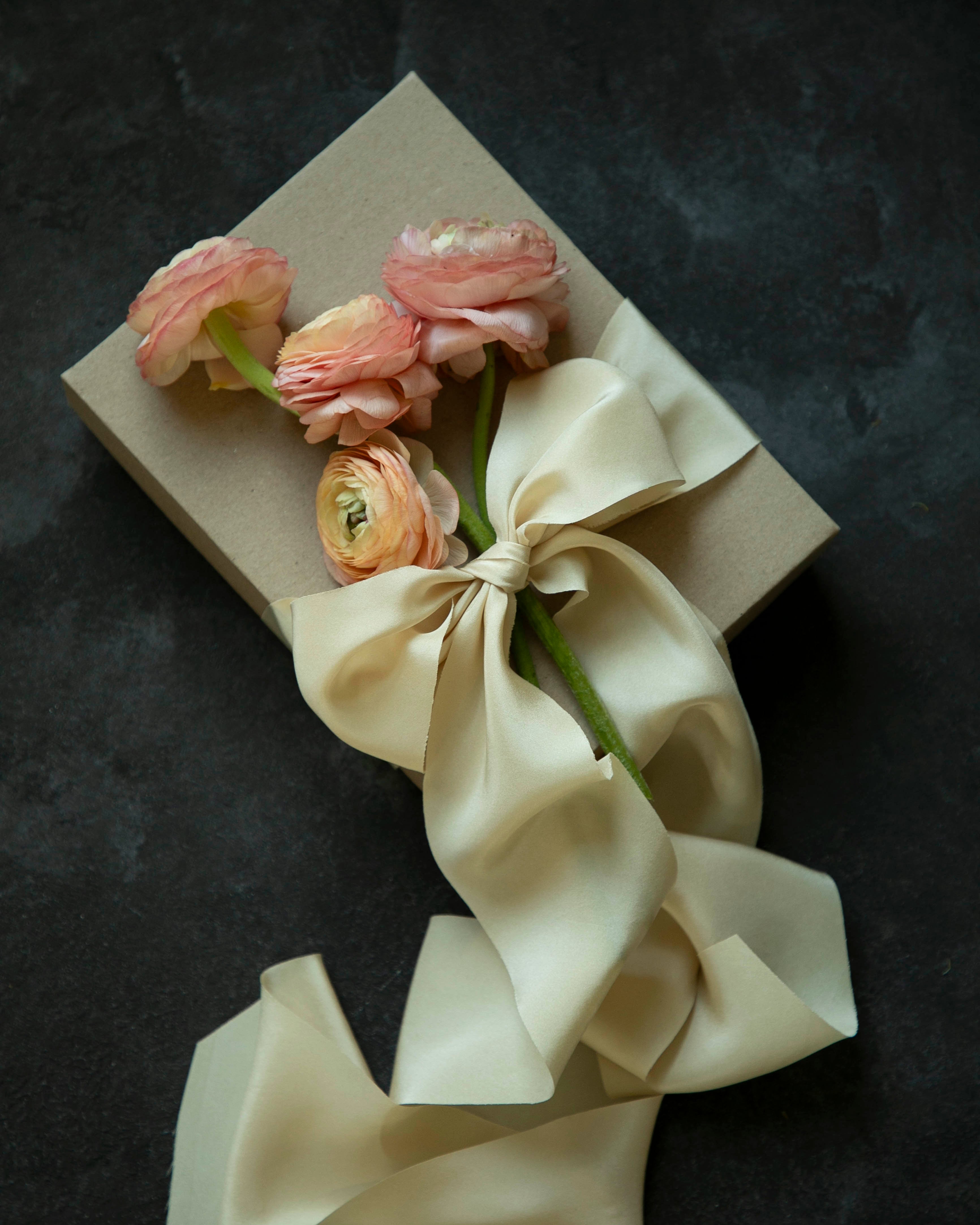 Bouquet of flowers tied with a bow on a gift box