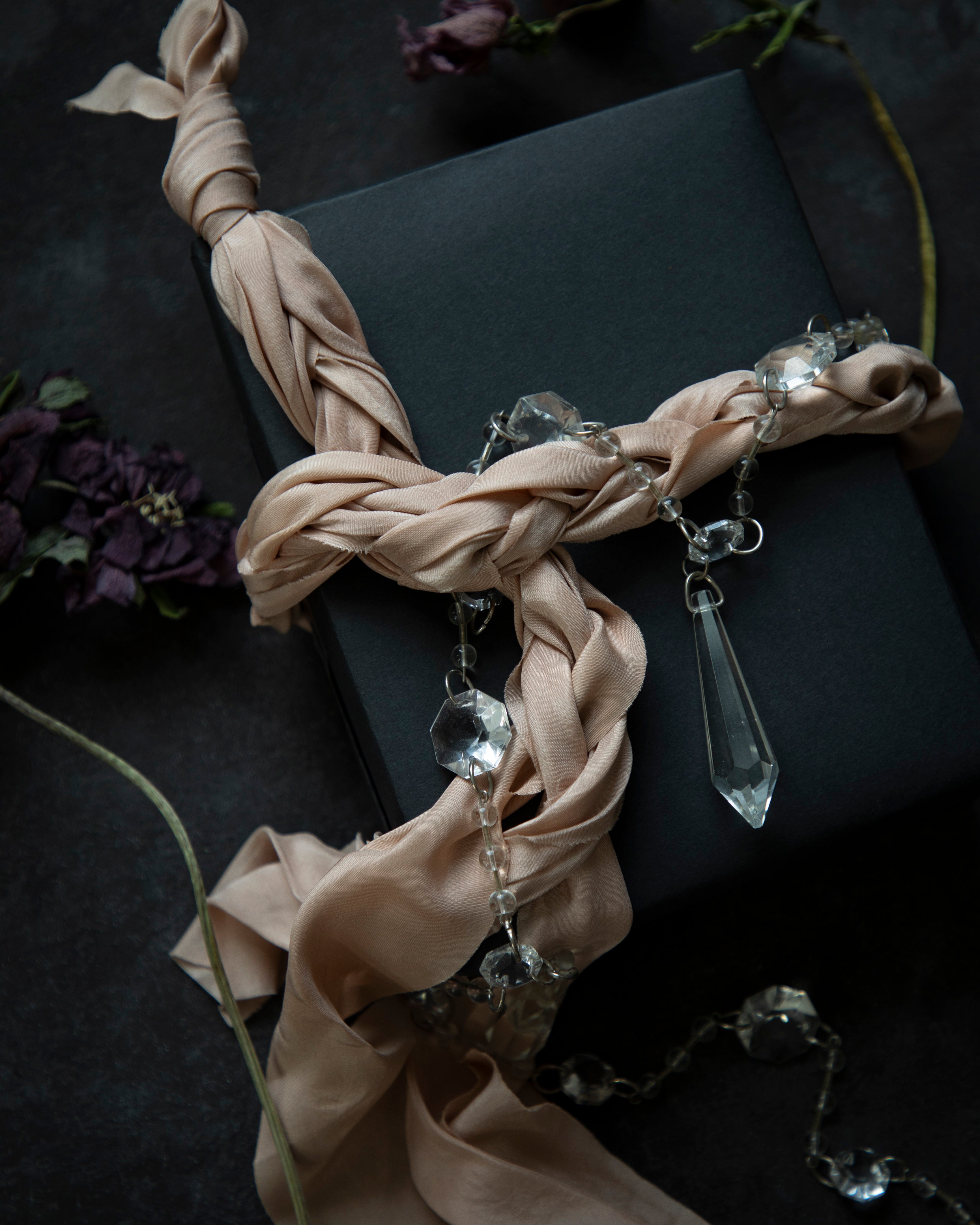 crystale and blush colored fabric and crystal pendants on a dark background