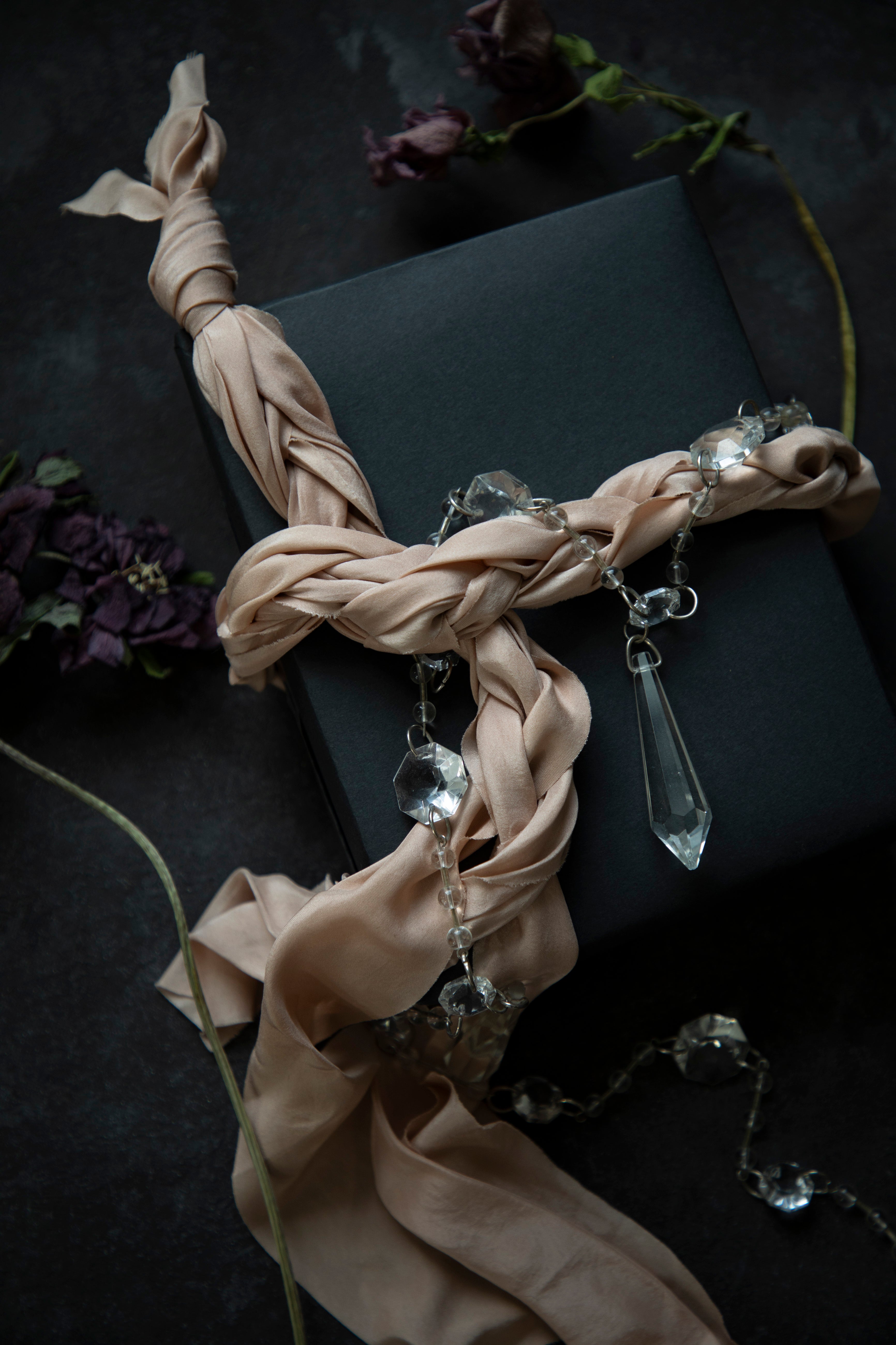 crystale and blush colored fabric and crystal pendants on a dark background