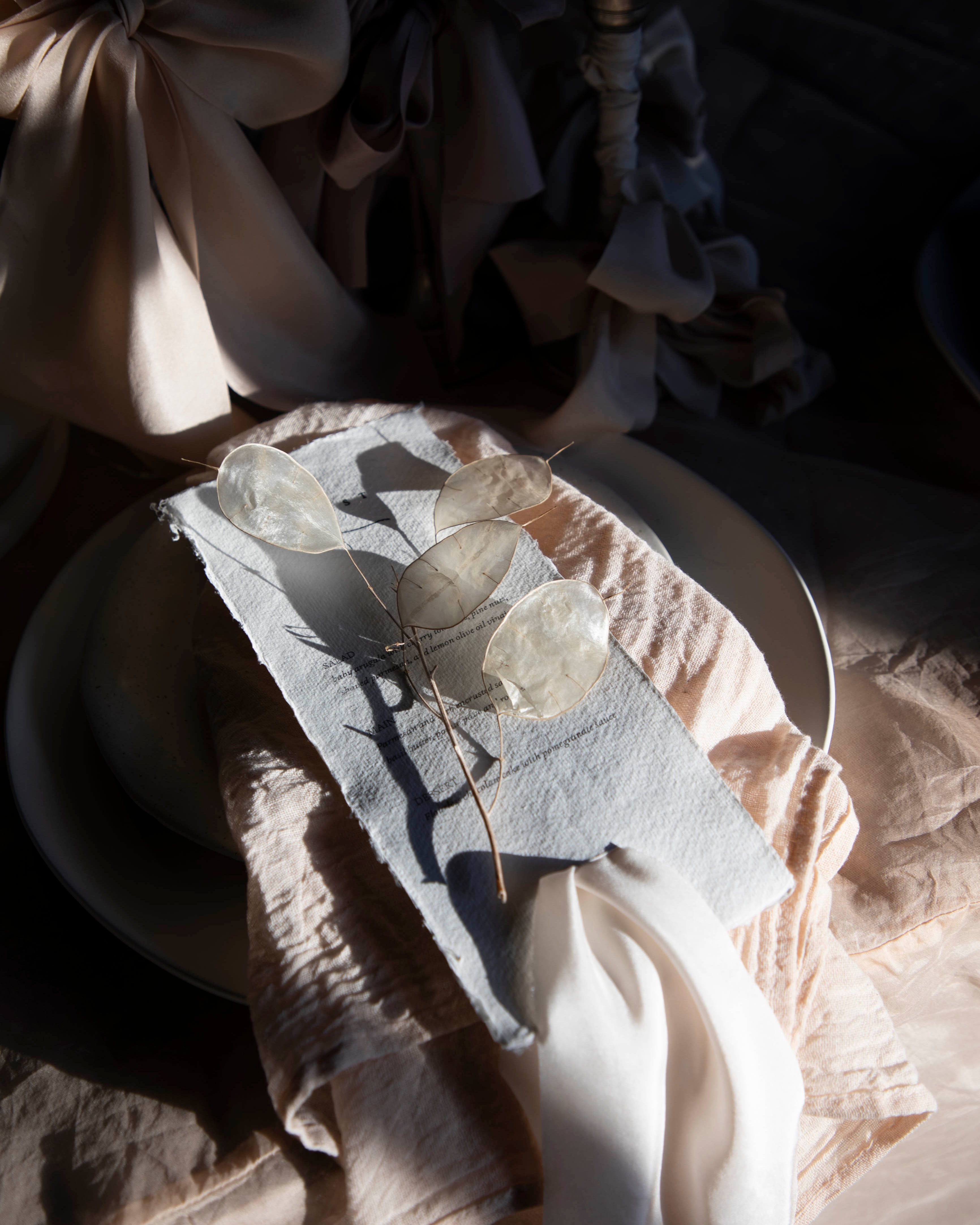 Decorative table setting with a napkin featuring butterfly design on a textured surface.