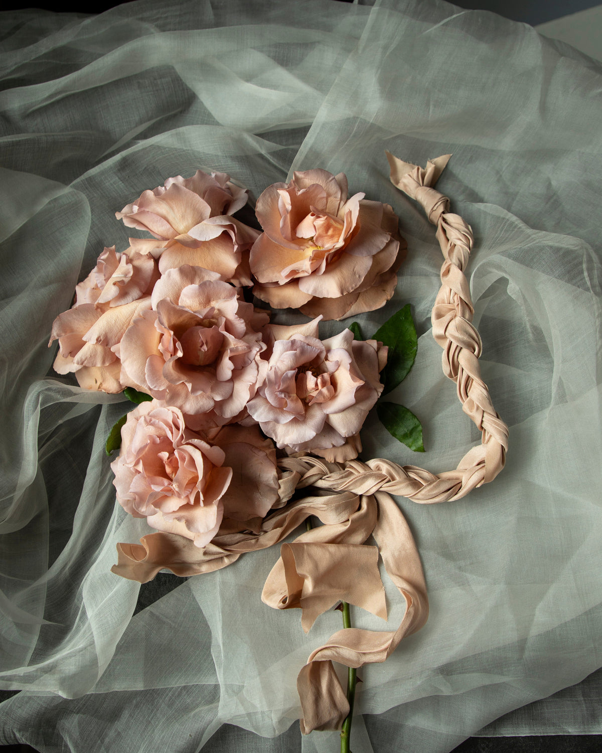 coral and blush roses with blush silk ribbon tired in a braid like hand-fasting rope