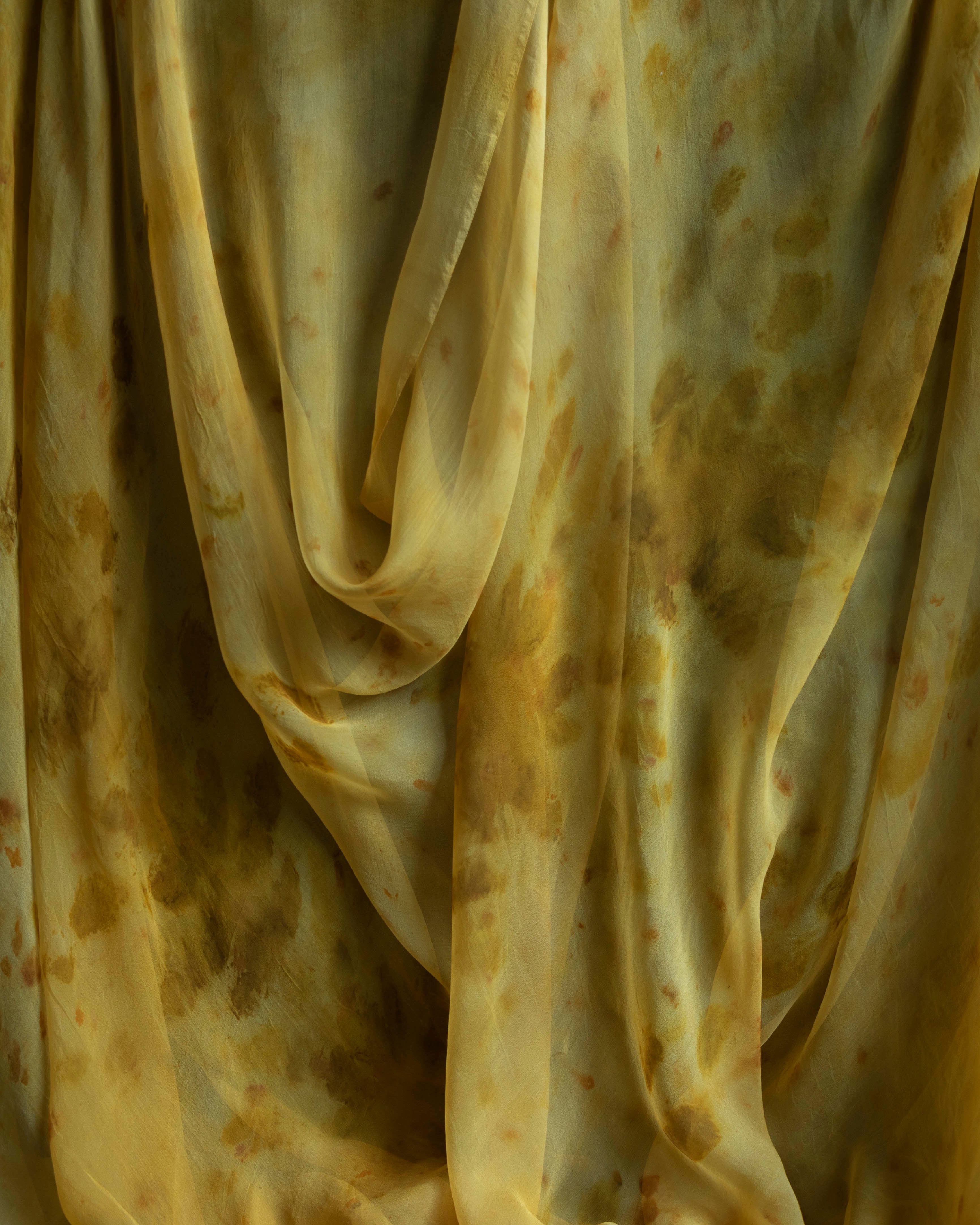 Sheer silk table runner with a botanical print featuring marigolds and chrysanthemums in shades of yellow, gold, burnt orange, and amber.