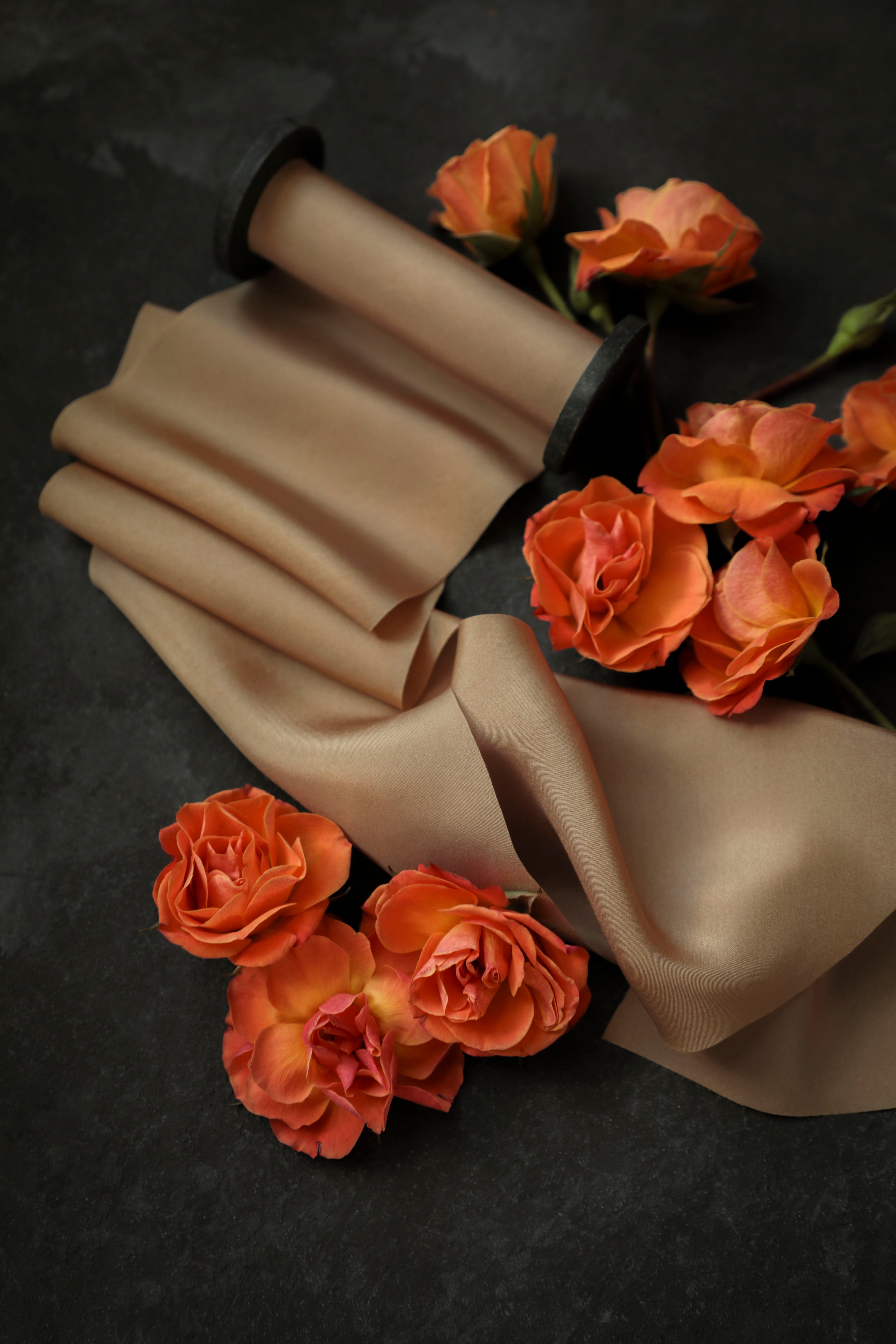cinnamon bridal bouquet, silk ribbon with orange flowers on a dark background