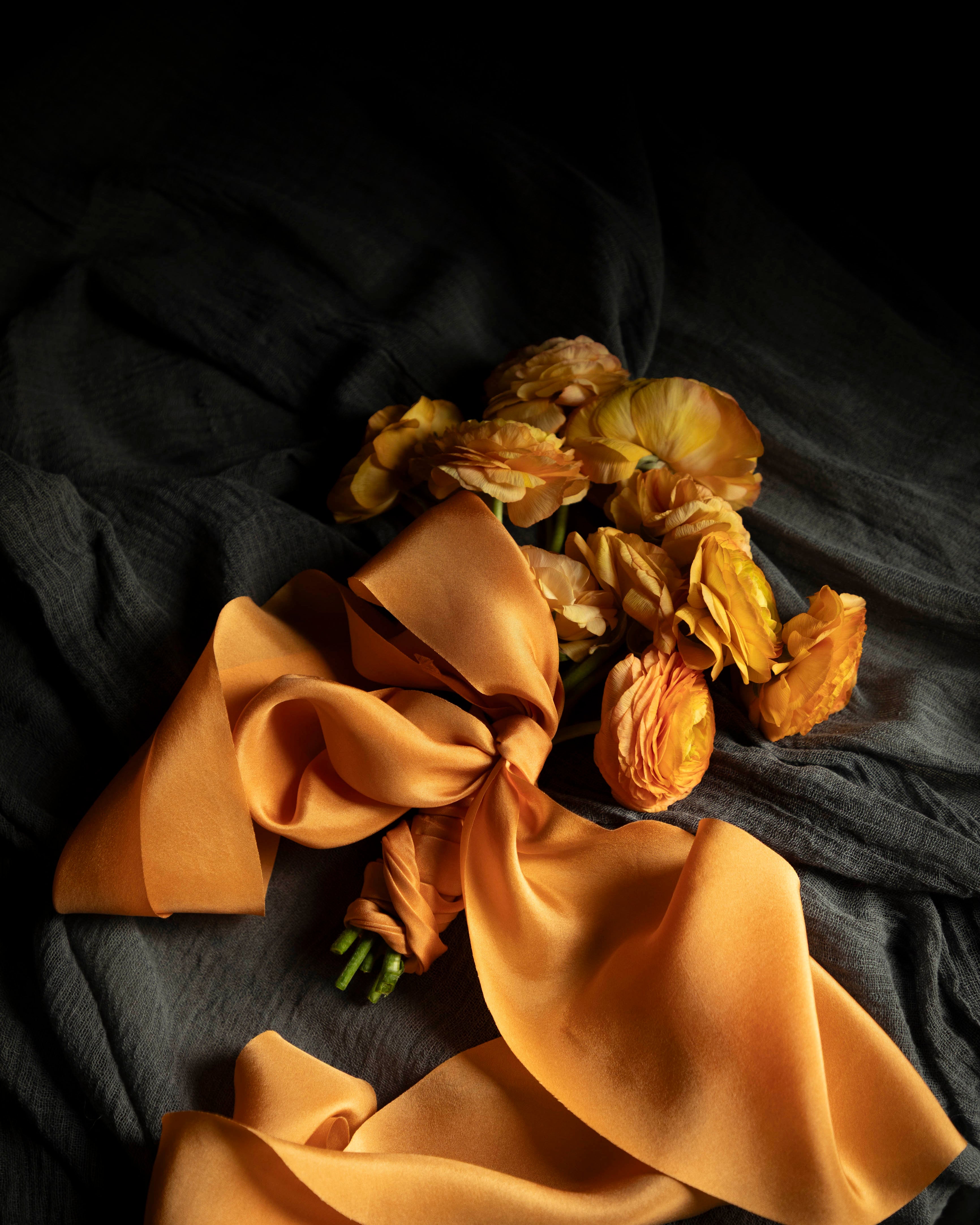 Orange ranunculus flower bouquet with orange silk ribbon
