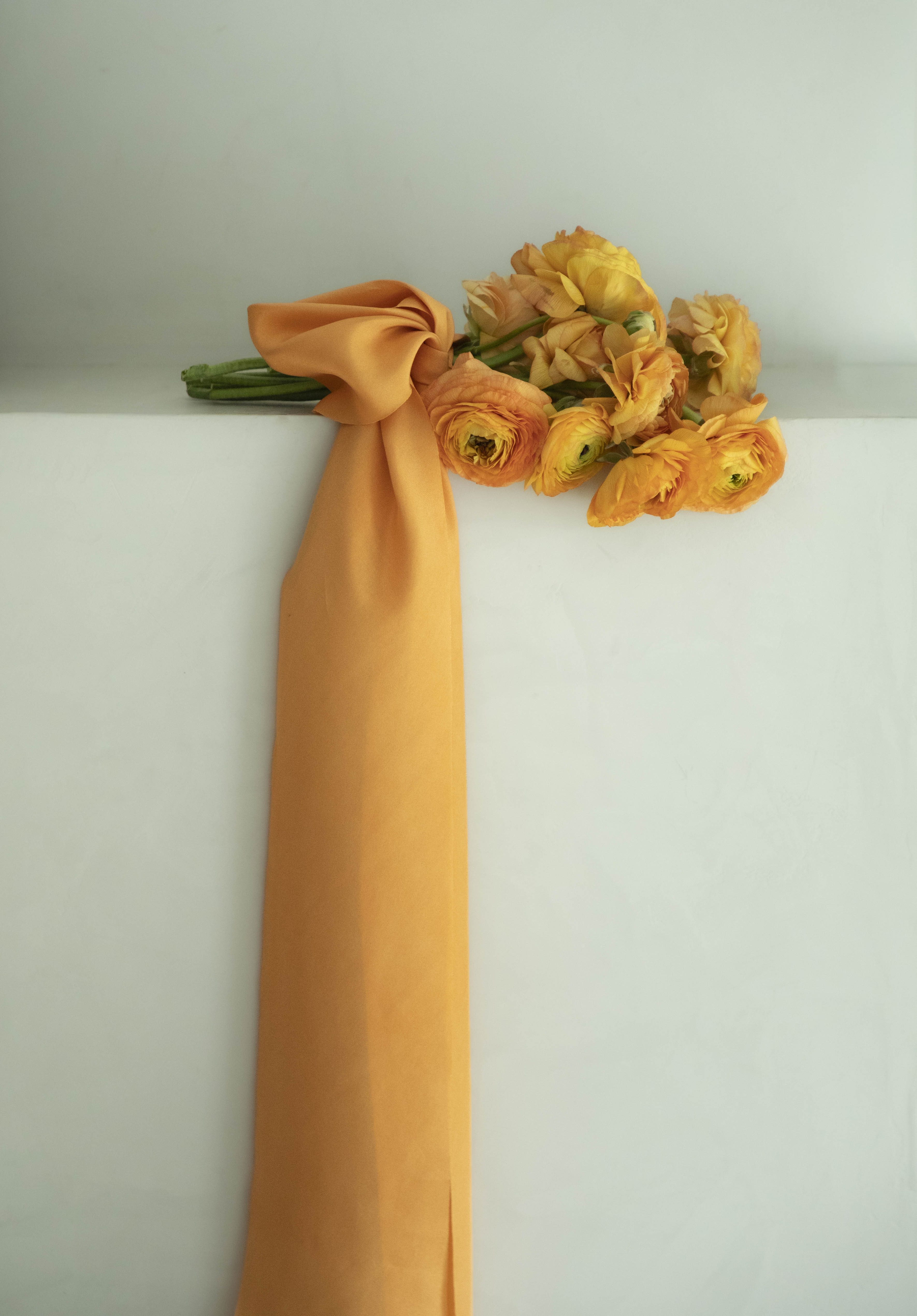 Orange ranunculus flower bouquet with orange silk ribbon