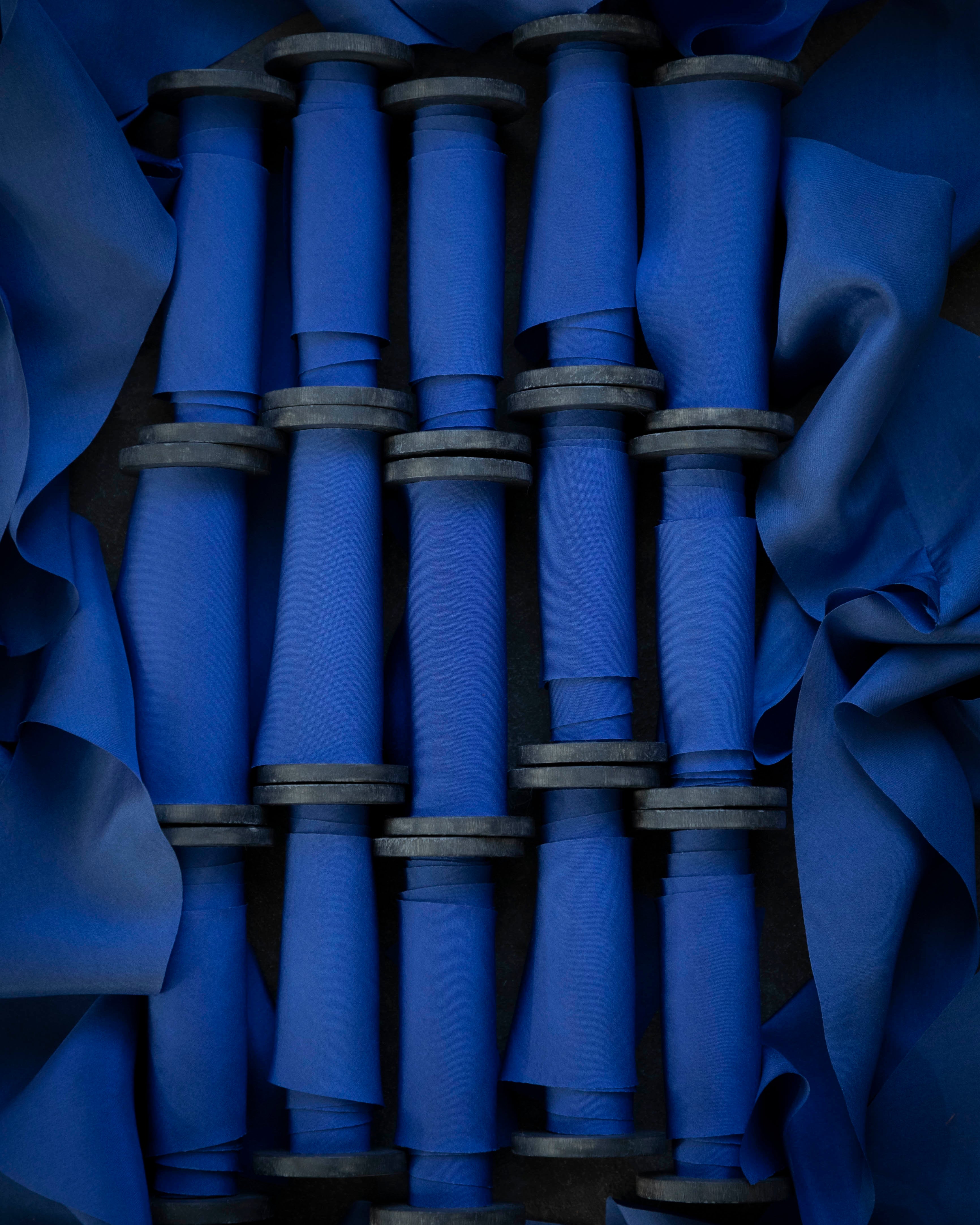 Blue fabric rolls stacked together with a dark blue background