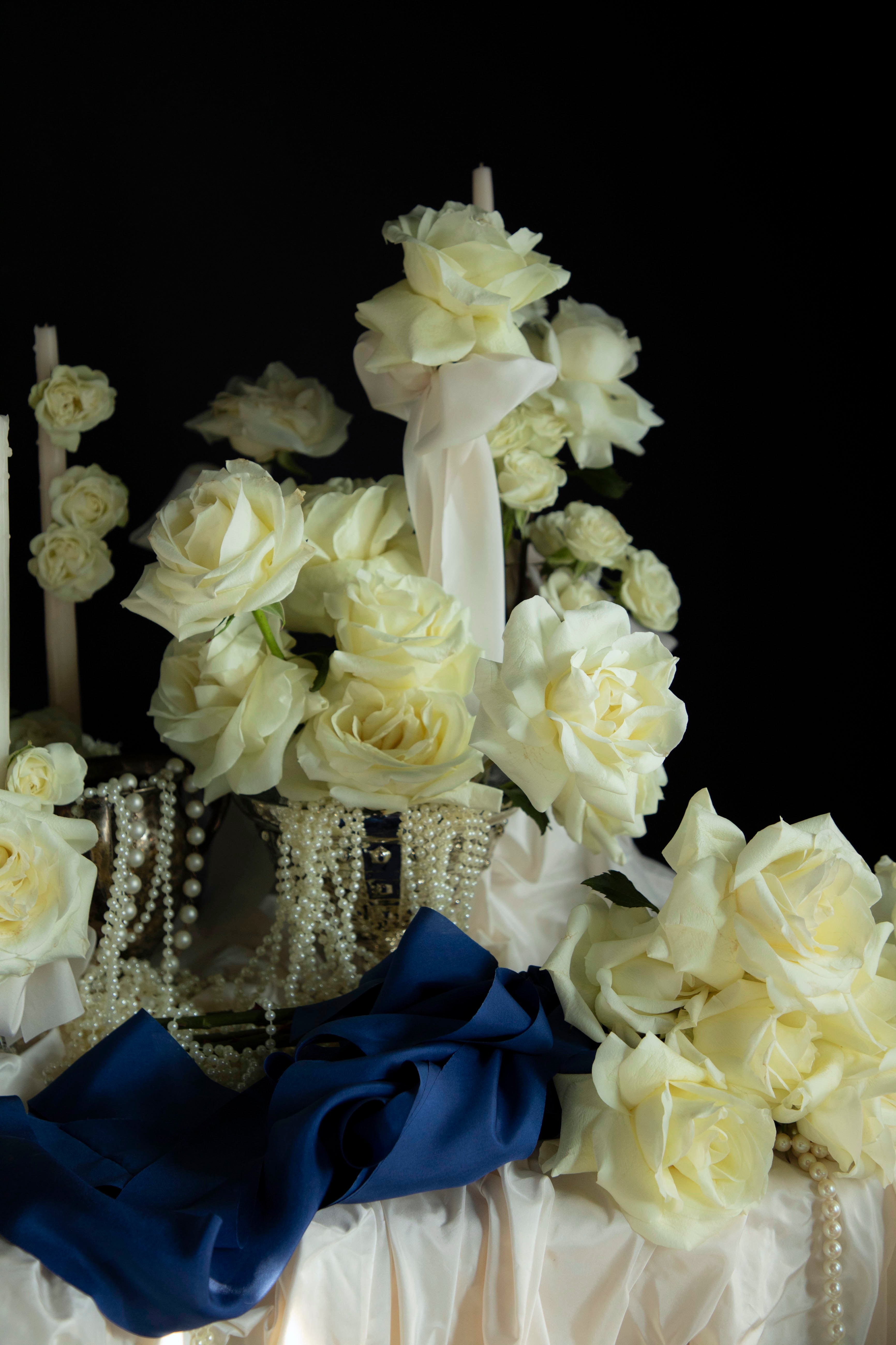 Decorative shoe with white flowers and a blue bow on a black background