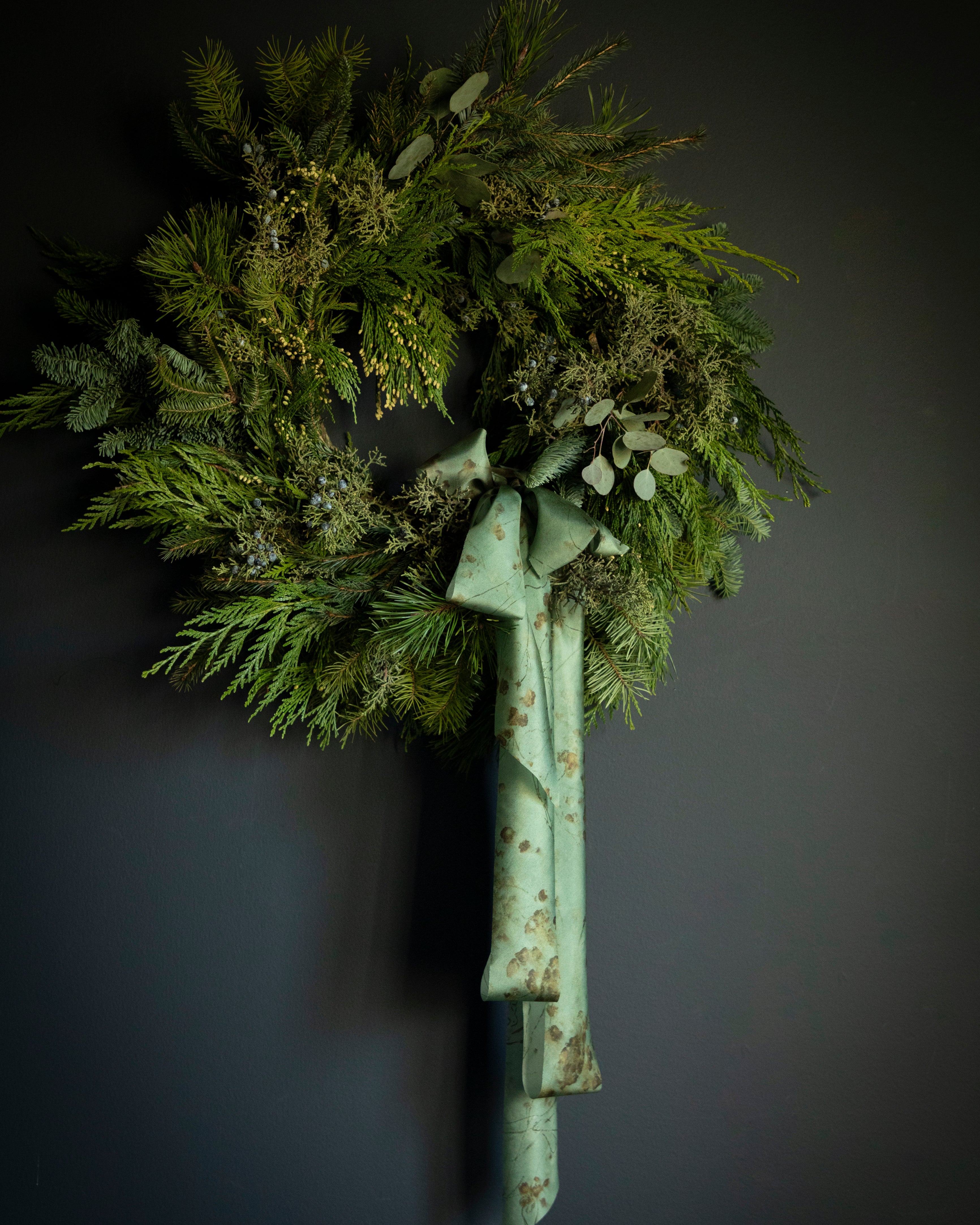 evergreen wreath with ribbon bow. Eco-friendly silk ribbons with nature-inspired patterns, perfect for unique gift wrapping and tying market bouquets, crafted from sustainable materials