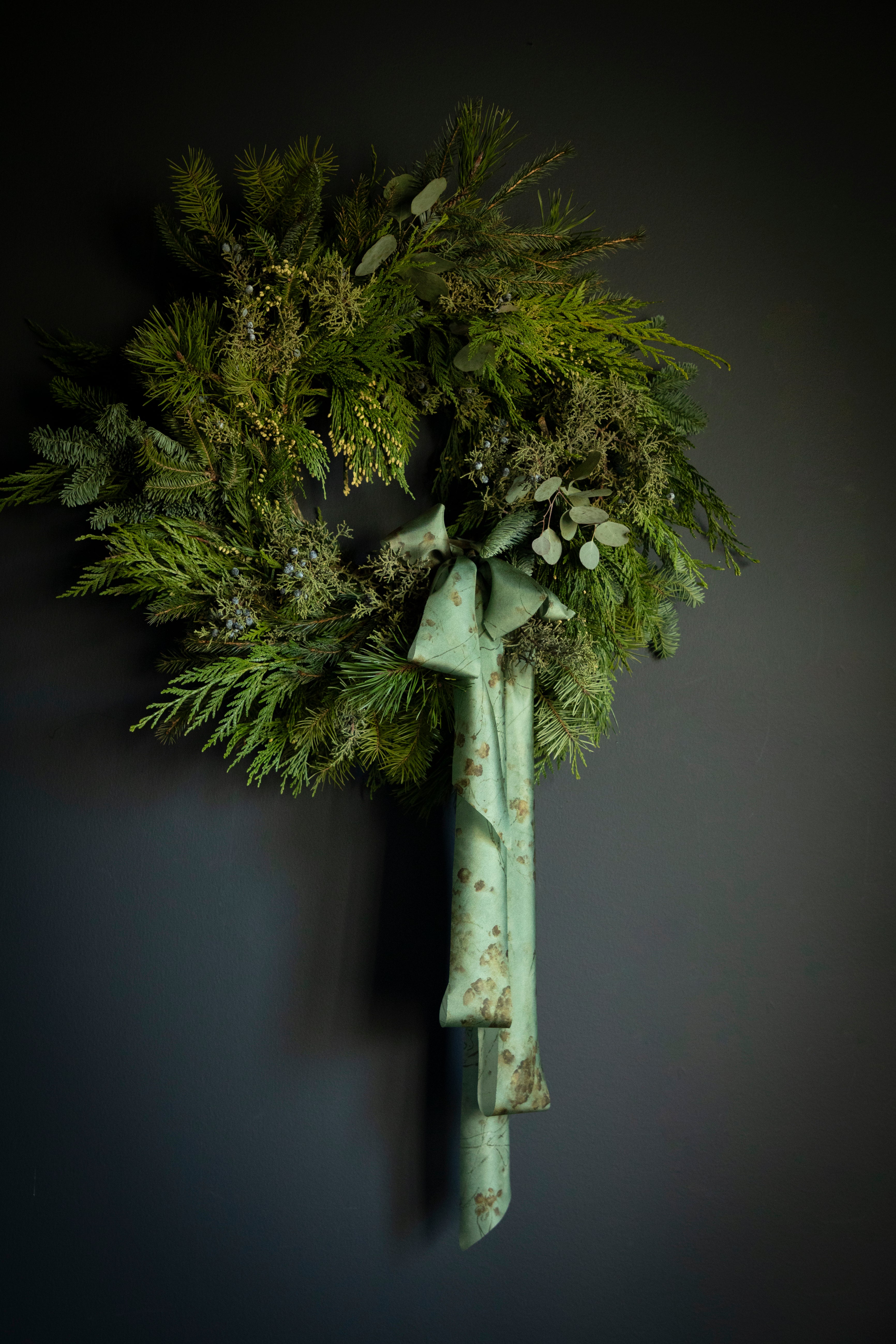 evergreen wreath with ribbon bow. Eco-friendly silk ribbons with nature-inspired patterns, perfect for unique gift wrapping and tying market bouquets, crafted from sustainable materials