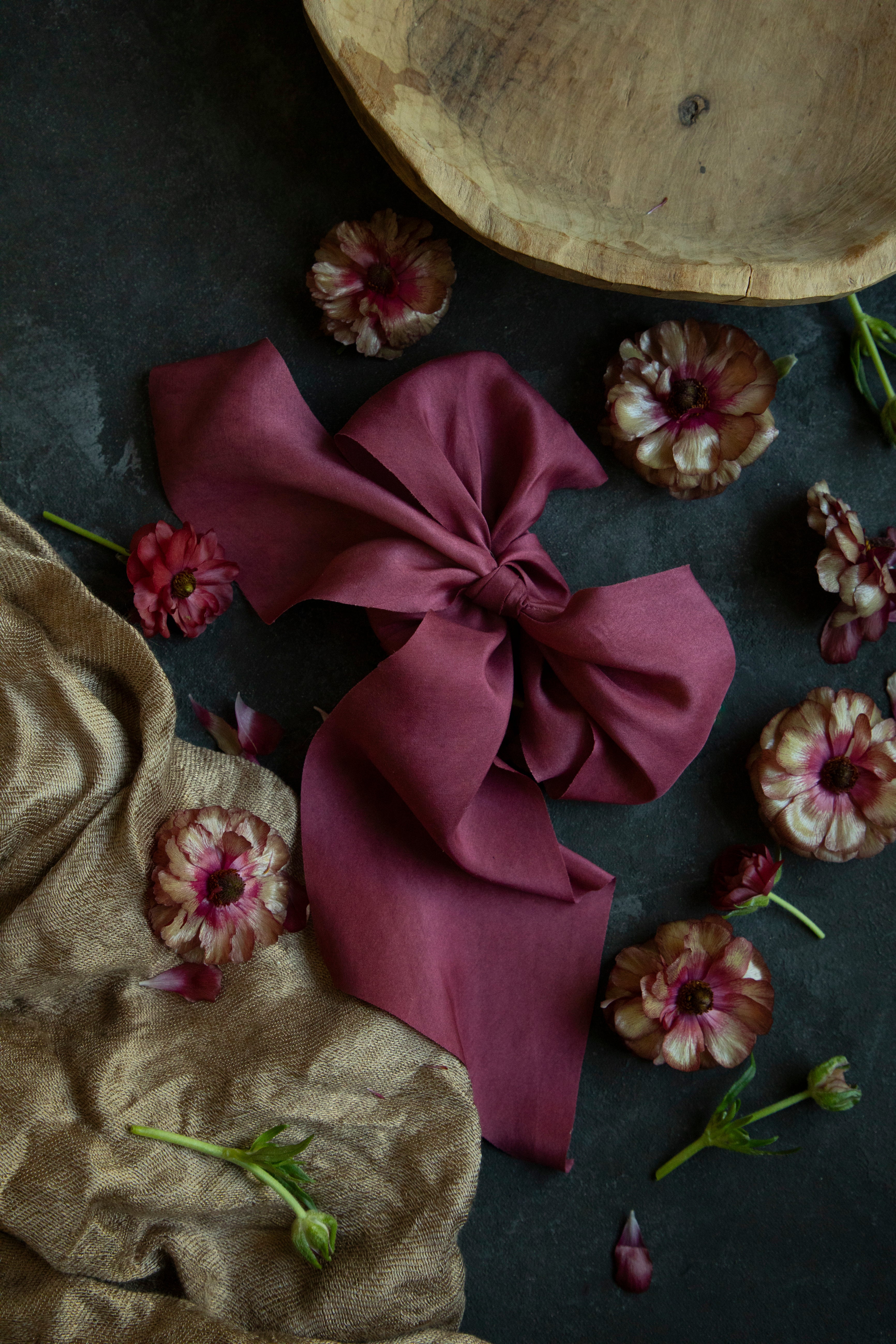 red ribbon on black surface next to a wooden bowl