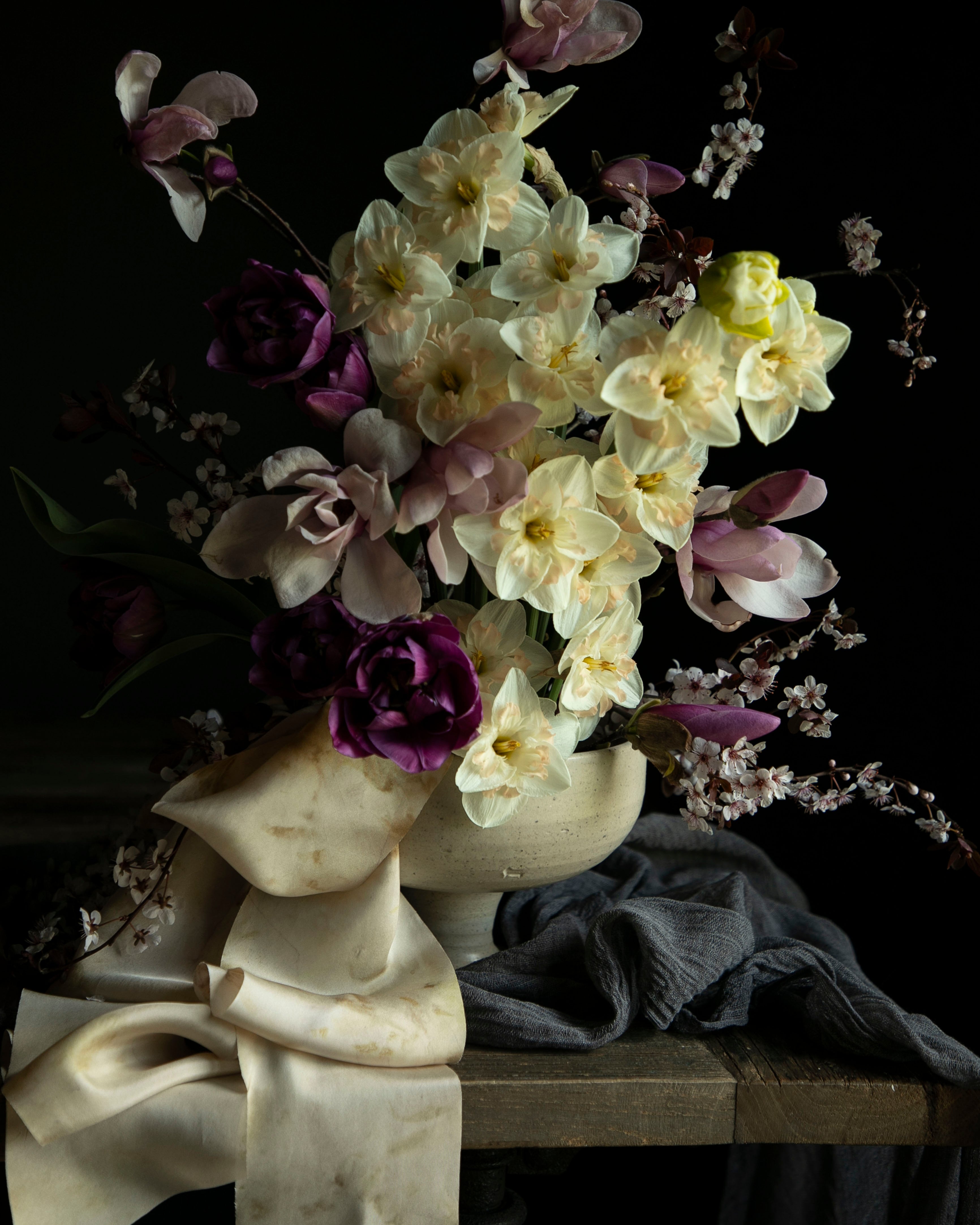 Floral arrangement in a sculpture-like vase on a dark background