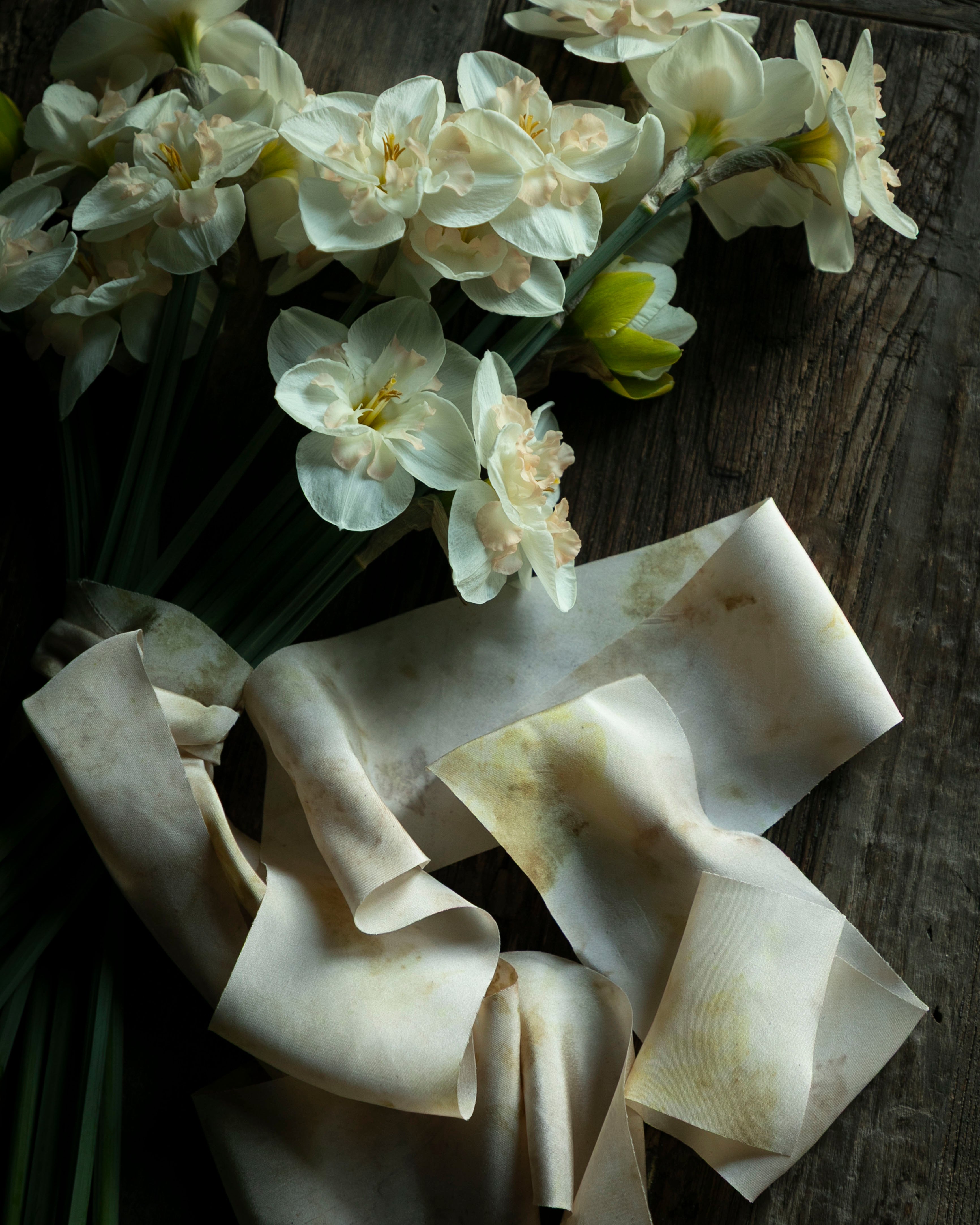 White flowers and ribbons on a wooden surface
