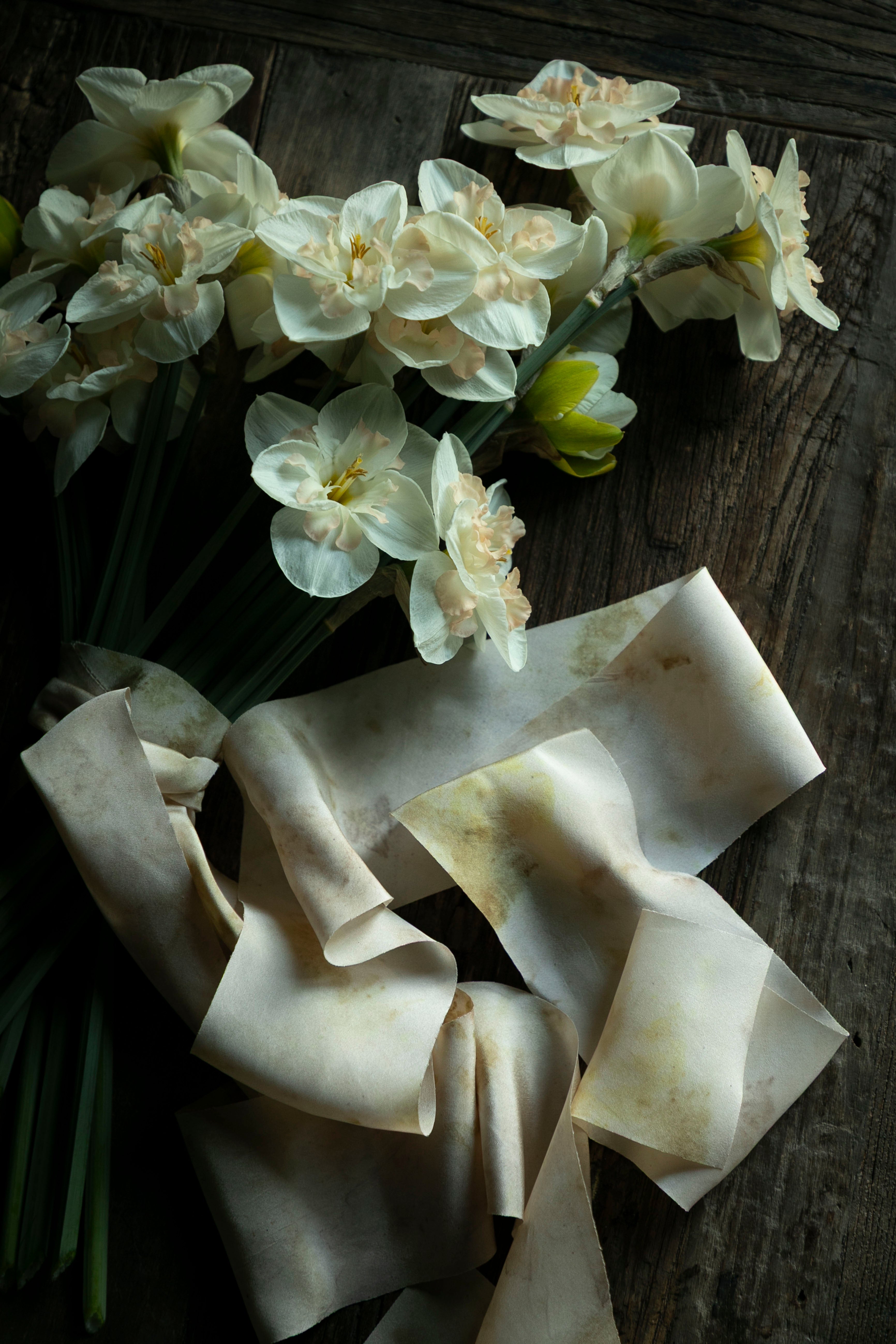 White flowers and ribbons on a wooden surface