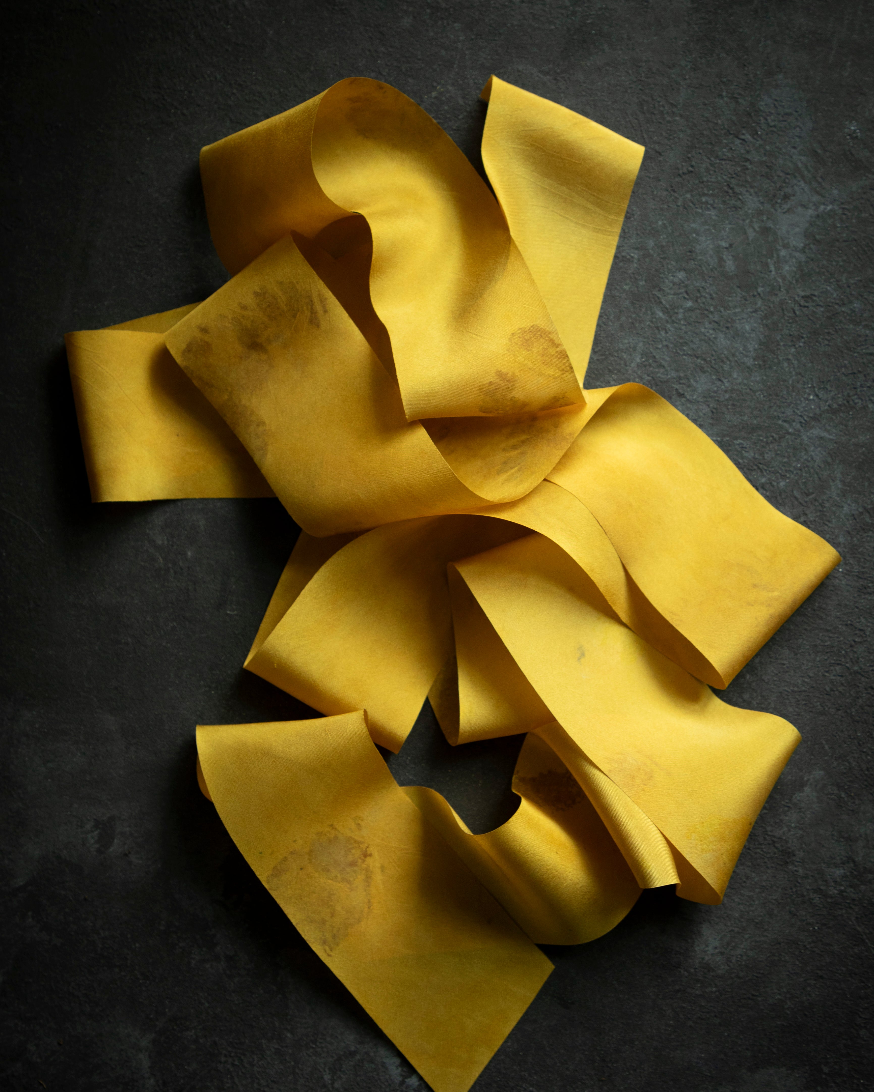hand dyed golden silk ribbon displayed on a black bakground