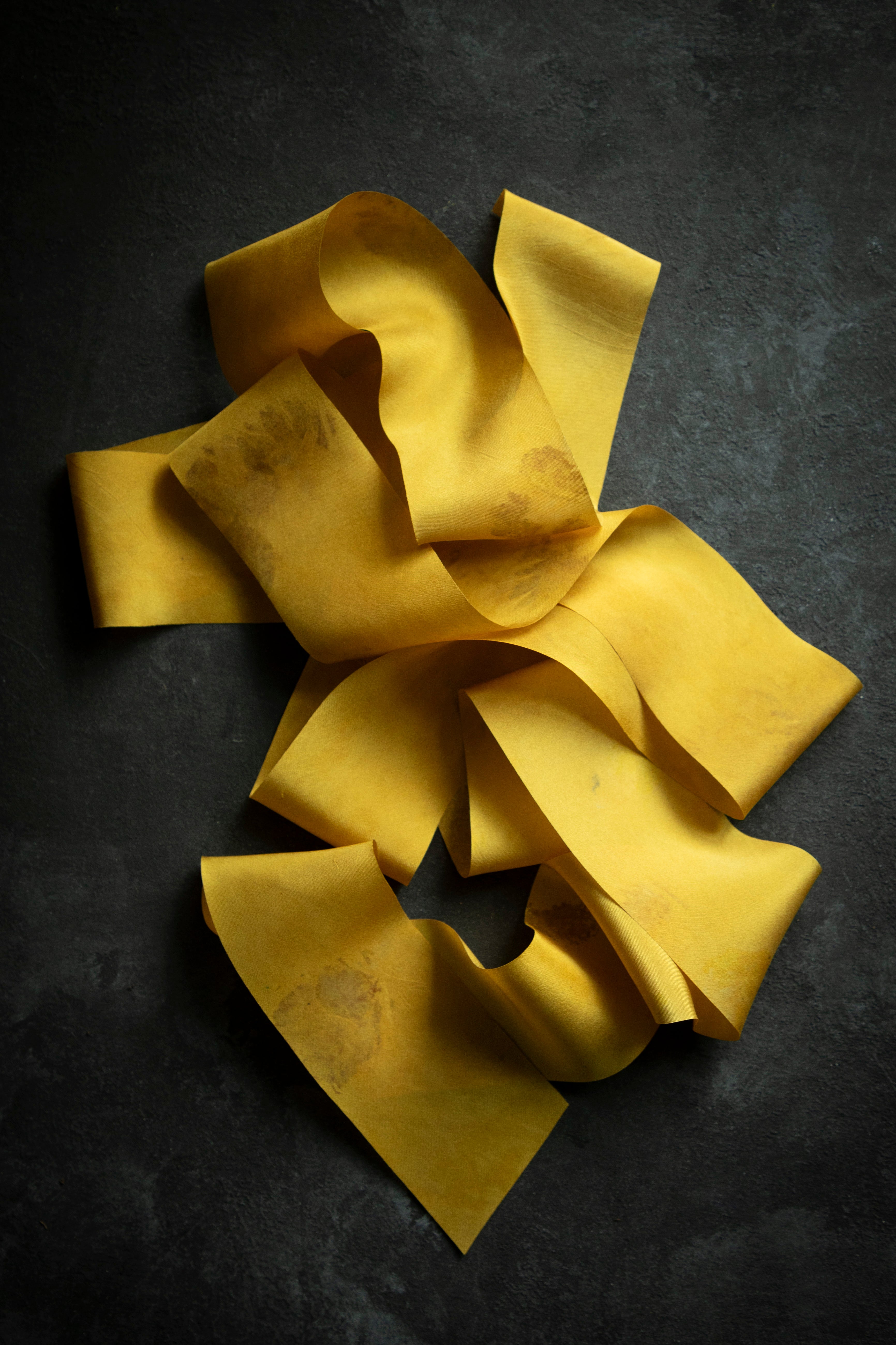 hand dyed golden silk ribbon displayed on a black bakground