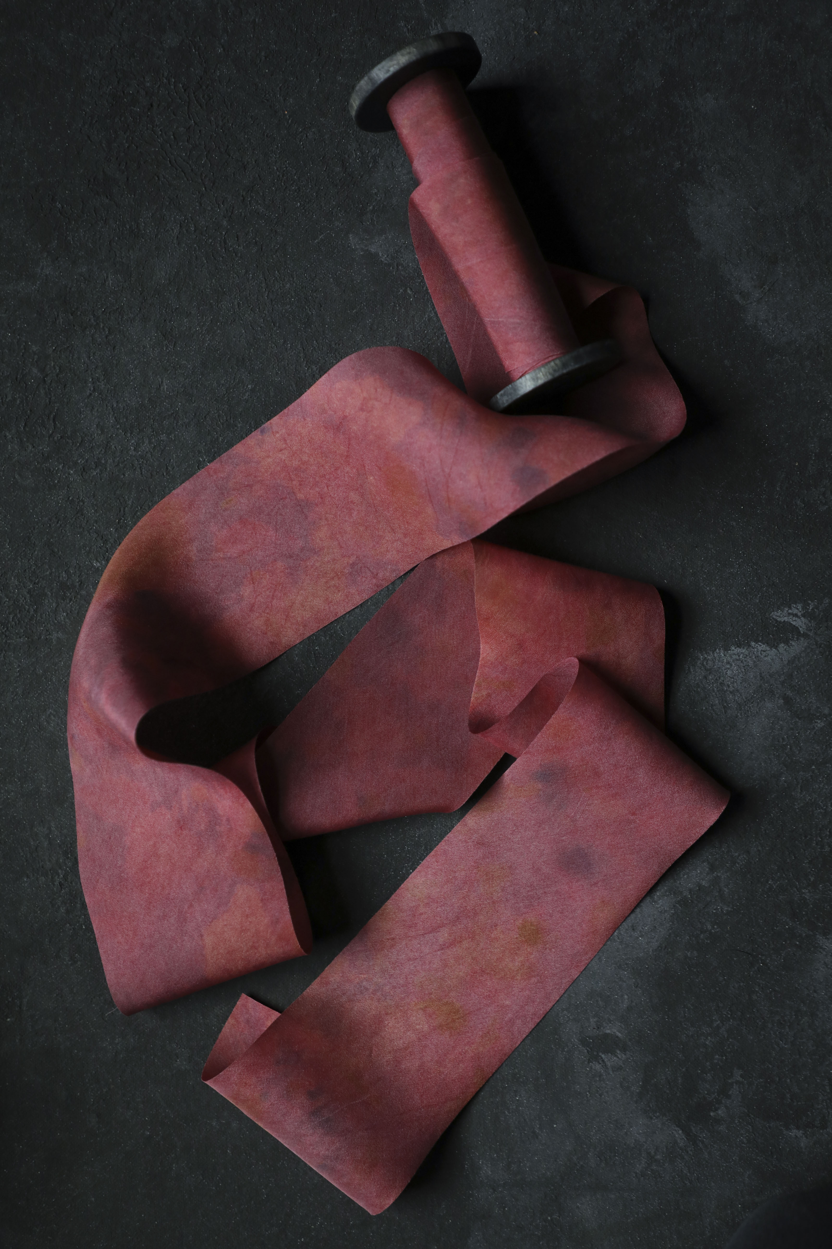 red ribbon on wood spool