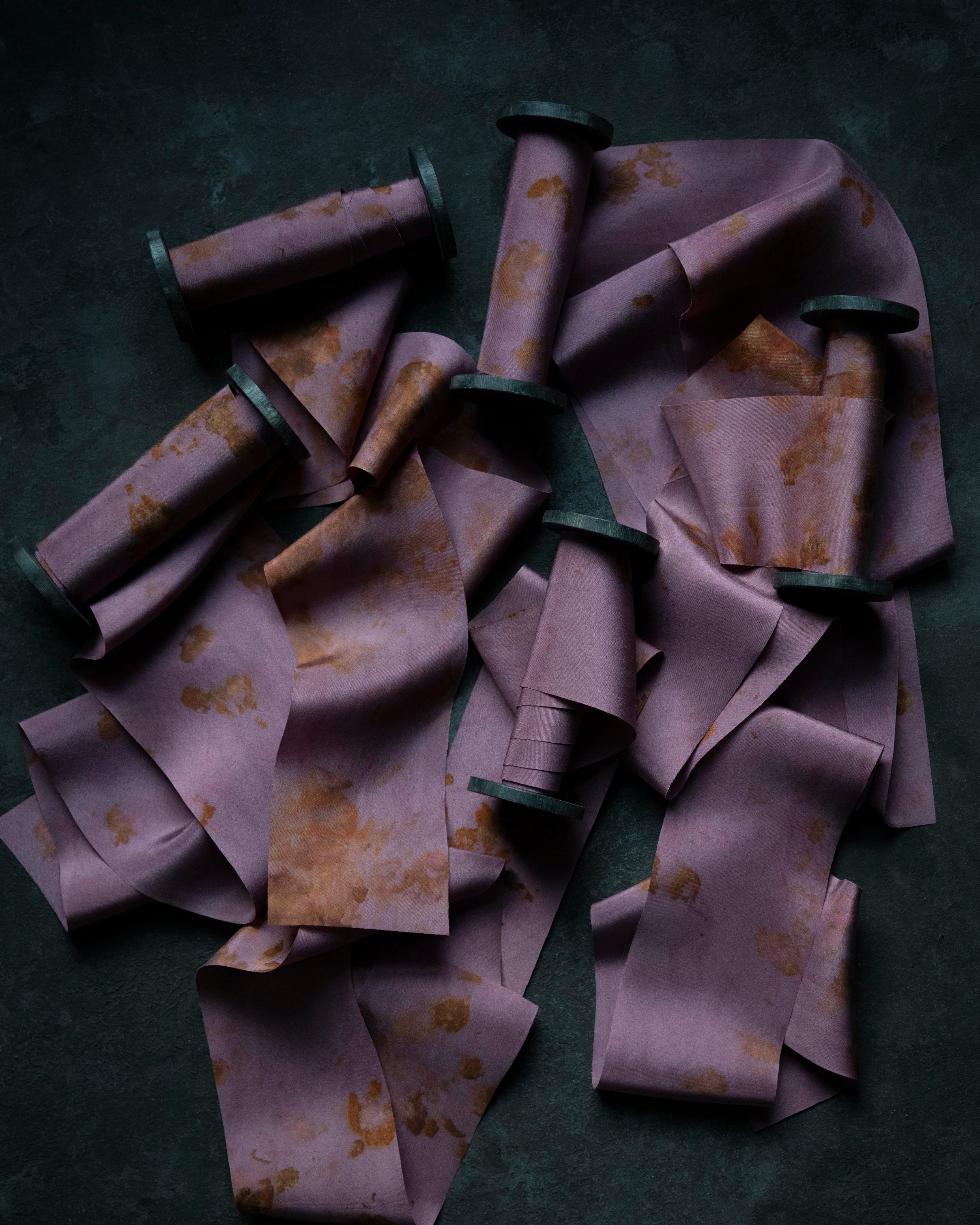 Purple ribbons with gold patterns scattered on a dark surface