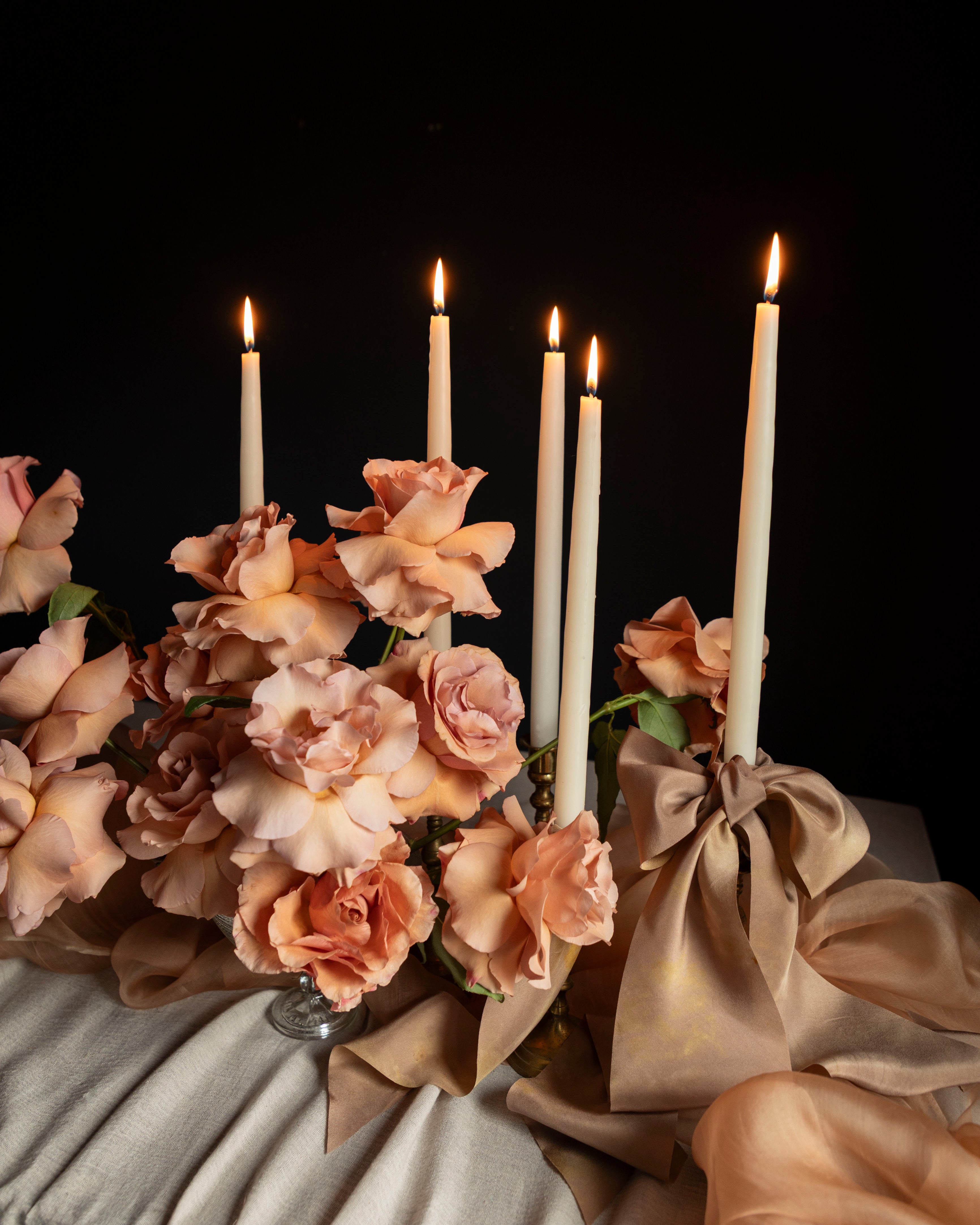 Decorative arrangement with candles and flowers on a dark background