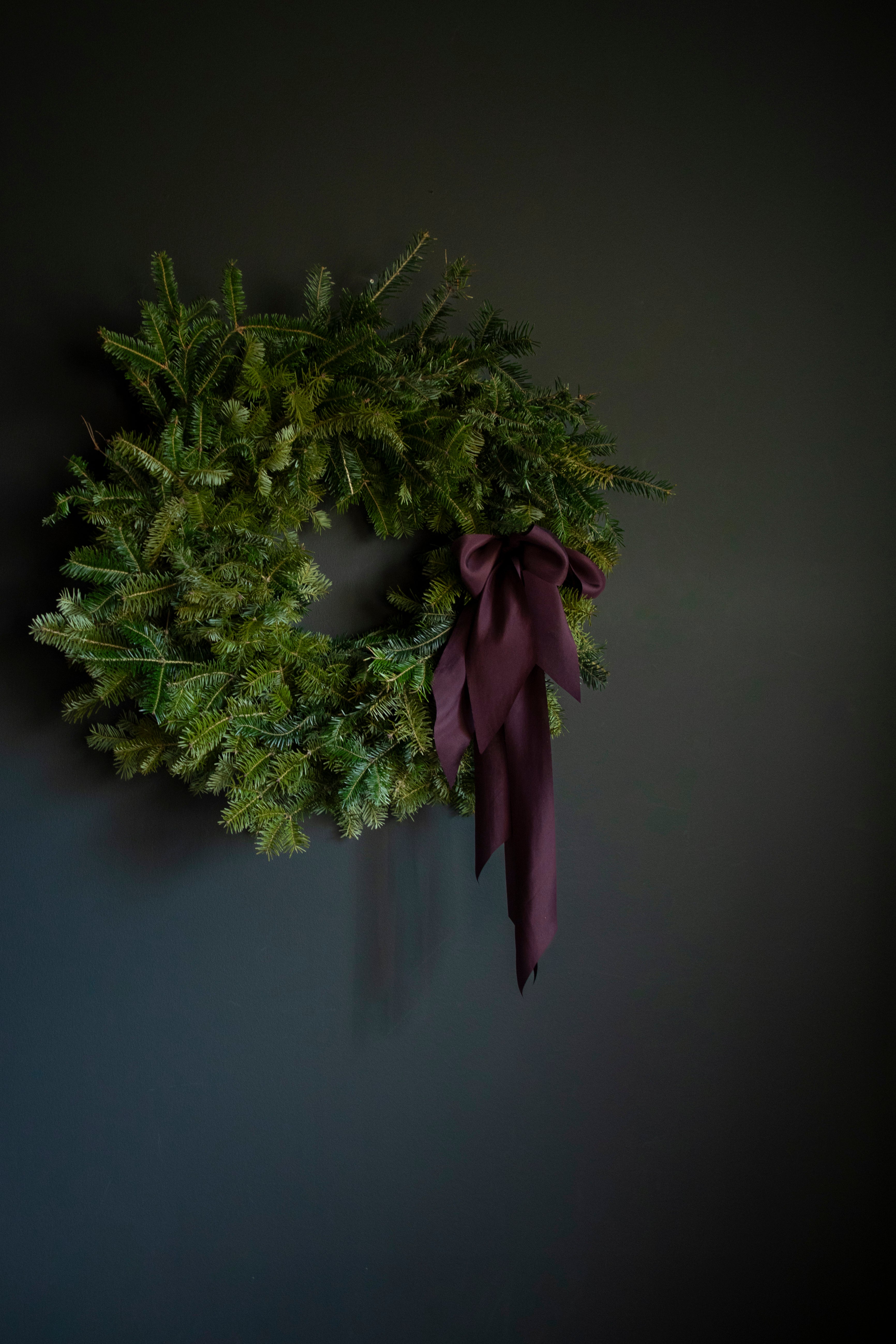 evergreen wreath with silk ribbon bows for the holiday