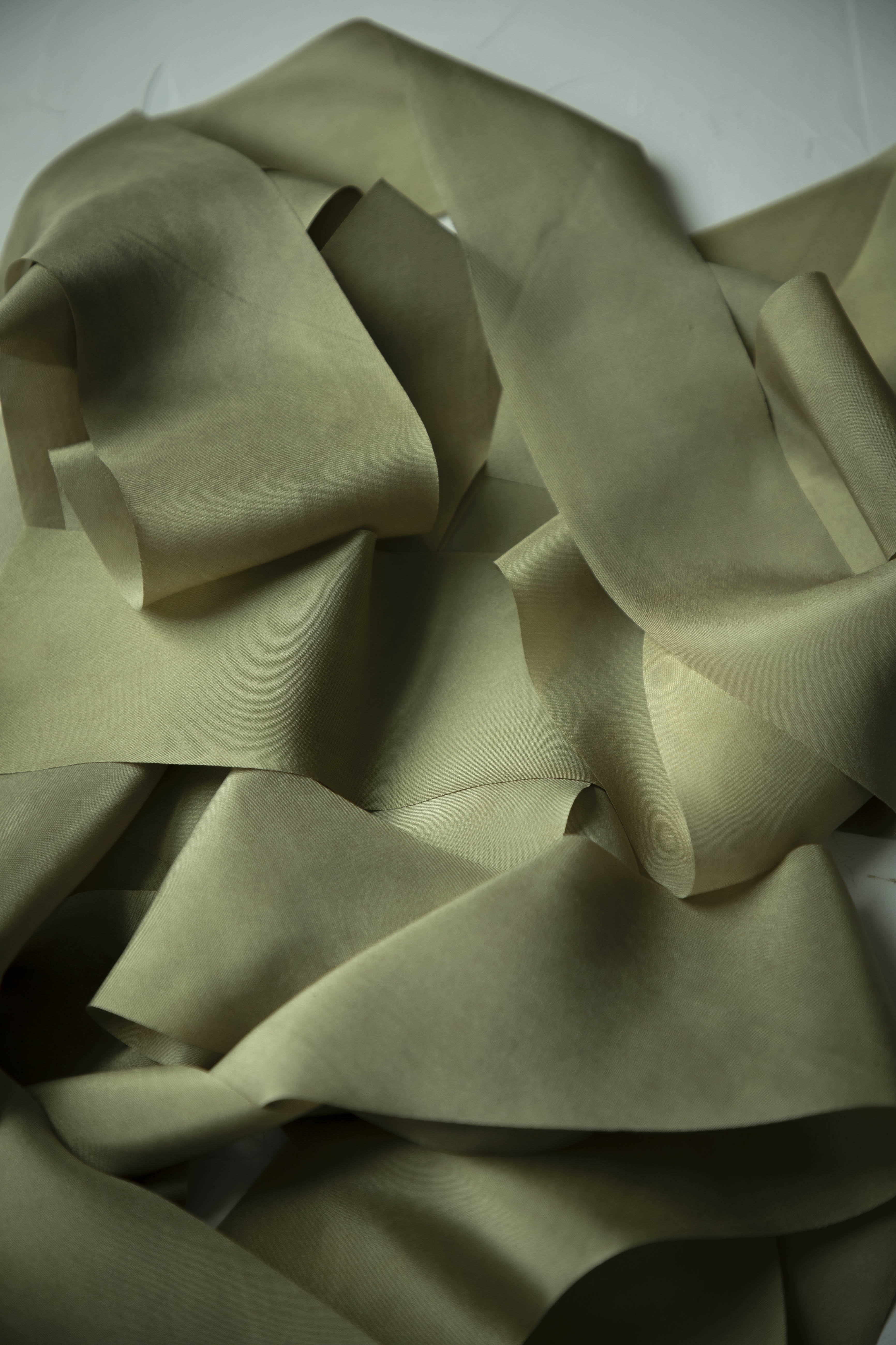 pile of green silk ribbons on a white background